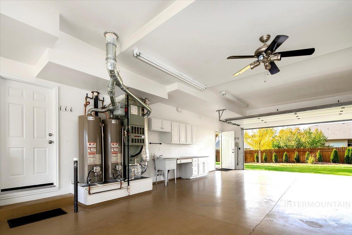 Garage with water heater, ceiling fan, and heating unit