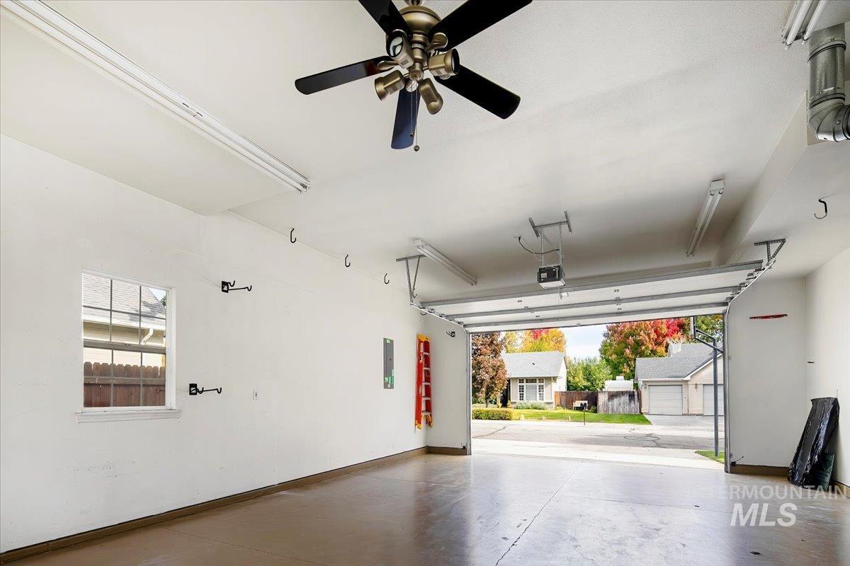 Garage featuring baseboards and electric panel