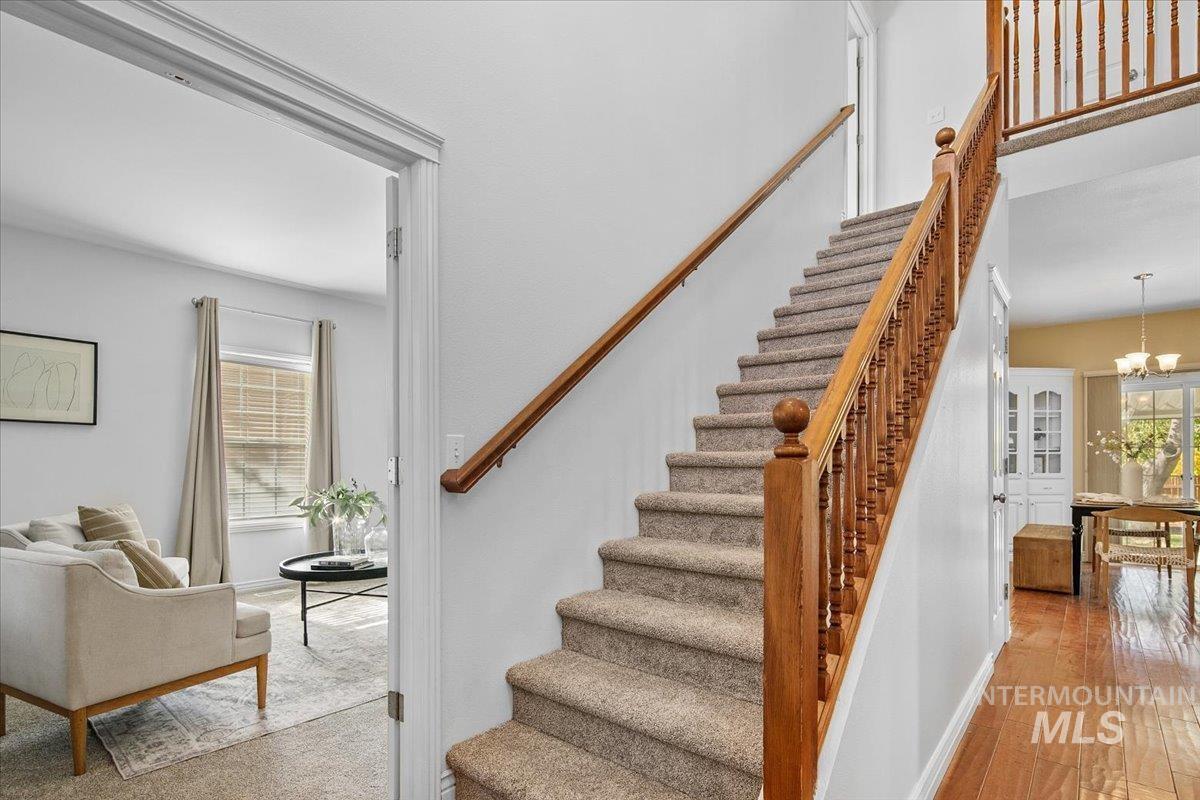 Staircase featuring a chandelier and wood finished floors