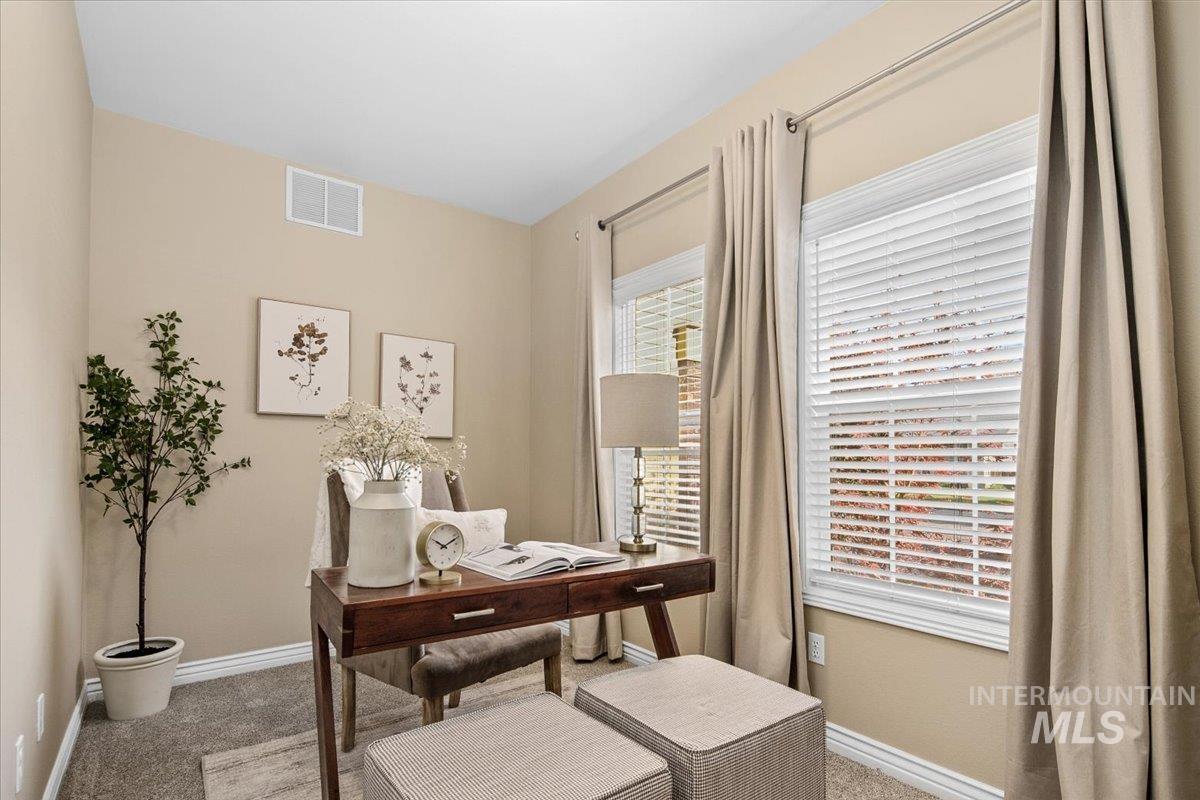 Carpeted home office featuring baseboards