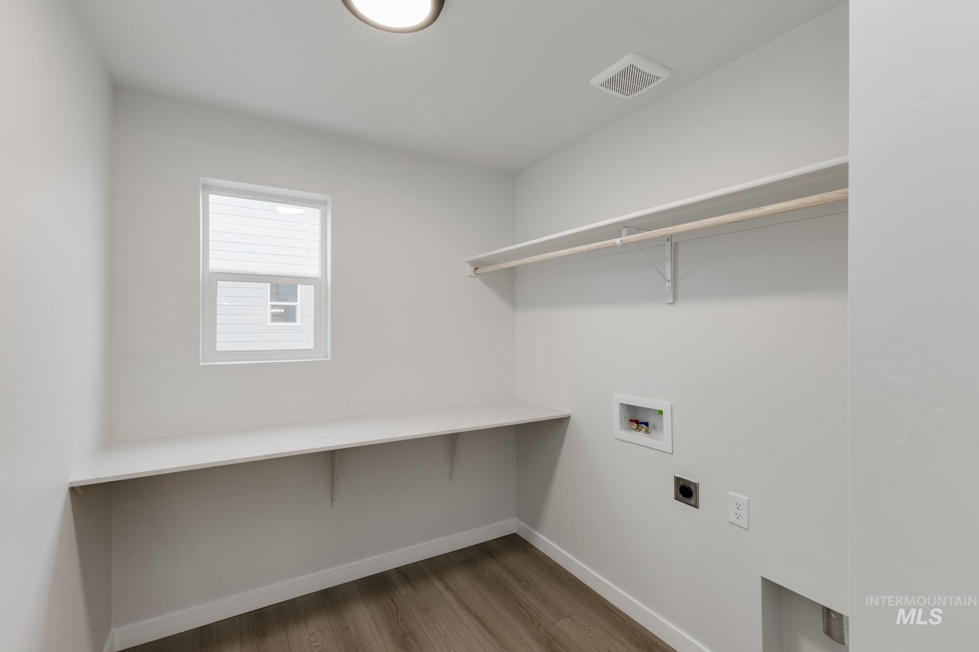 Laundry area with light wood-style floors, electric dryer hookup, and hookup for a washing machine