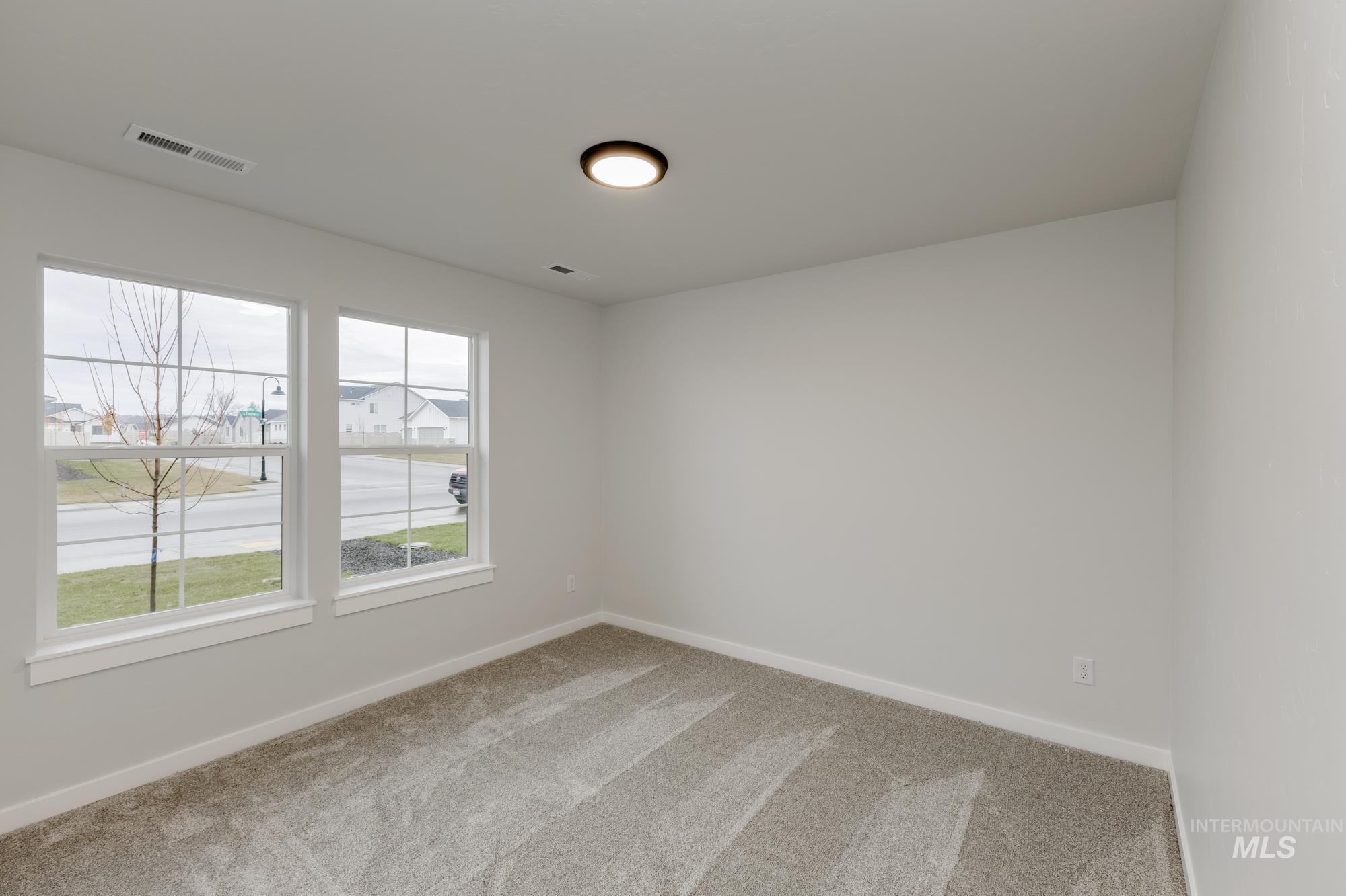 Spare room with light carpet and baseboards