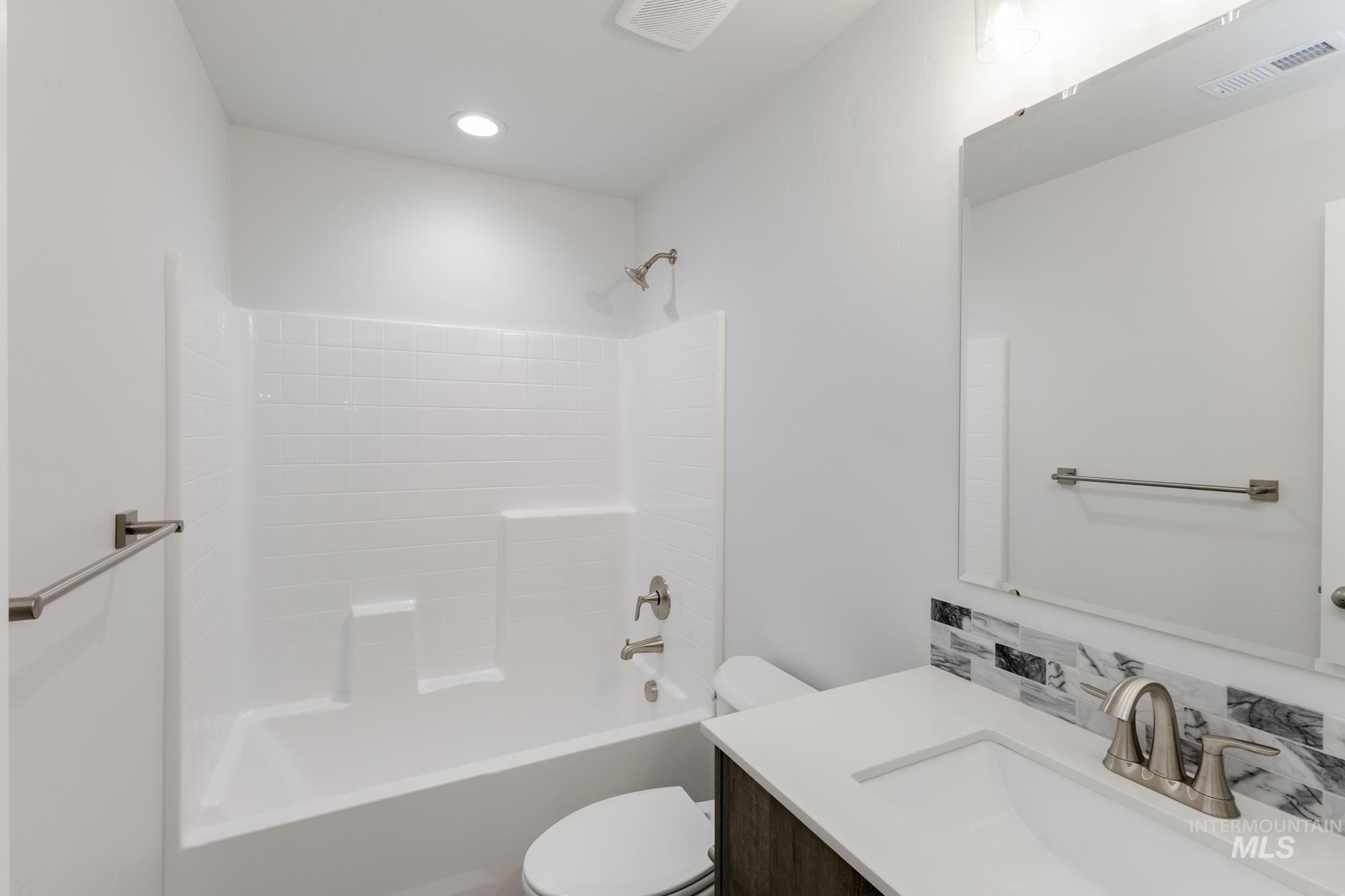 Full bath with shower / bathtub combination, vanity, and backsplash