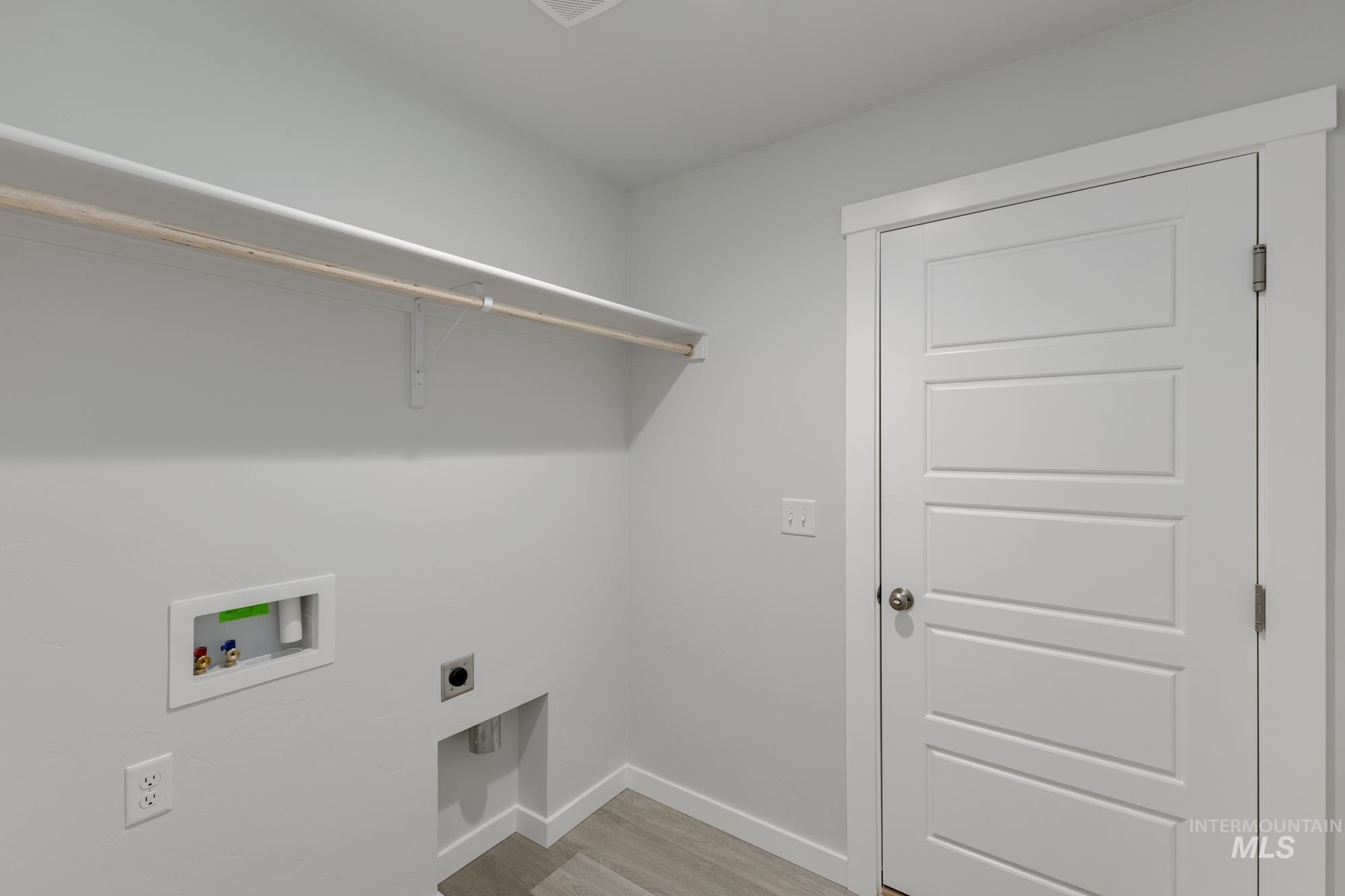 Washroom with light wood finished floors, electric dryer hookup, and hookup for a washing machine