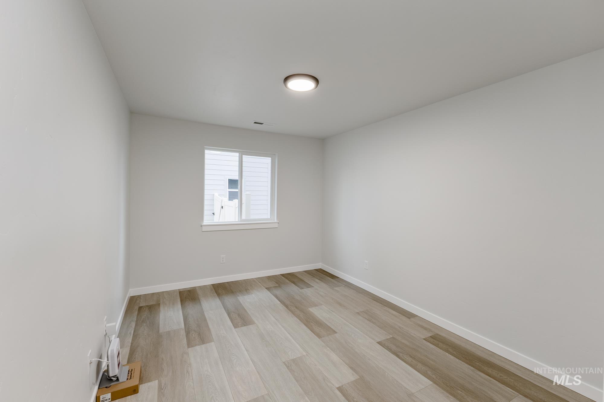 Unfurnished room with light wood-type flooring and baseboards