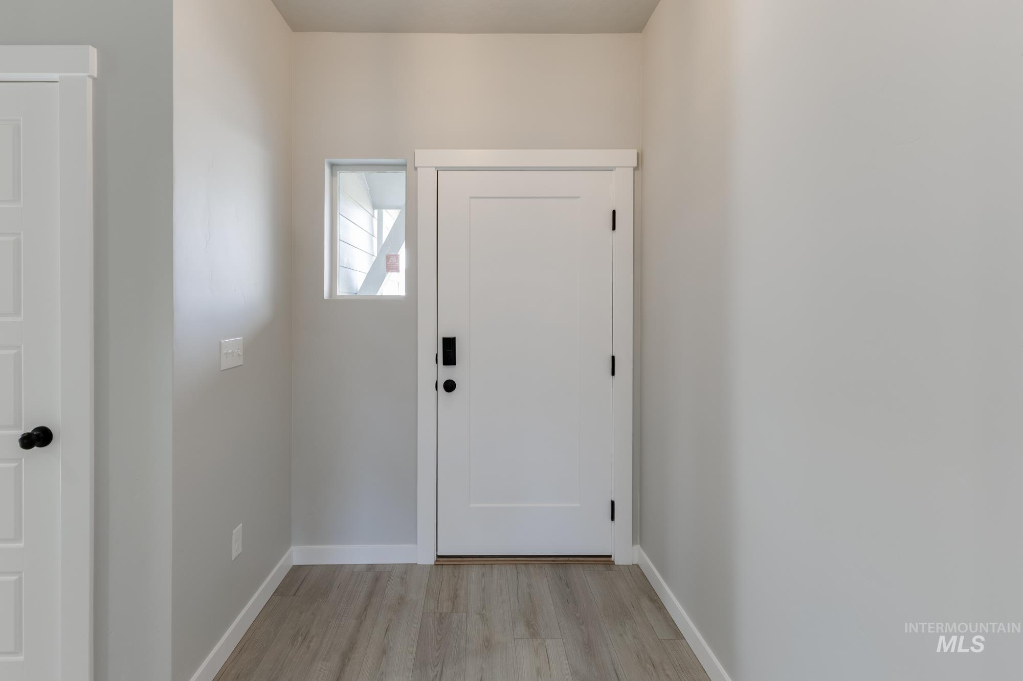 Entryway featuring baseboards and wood finished floors