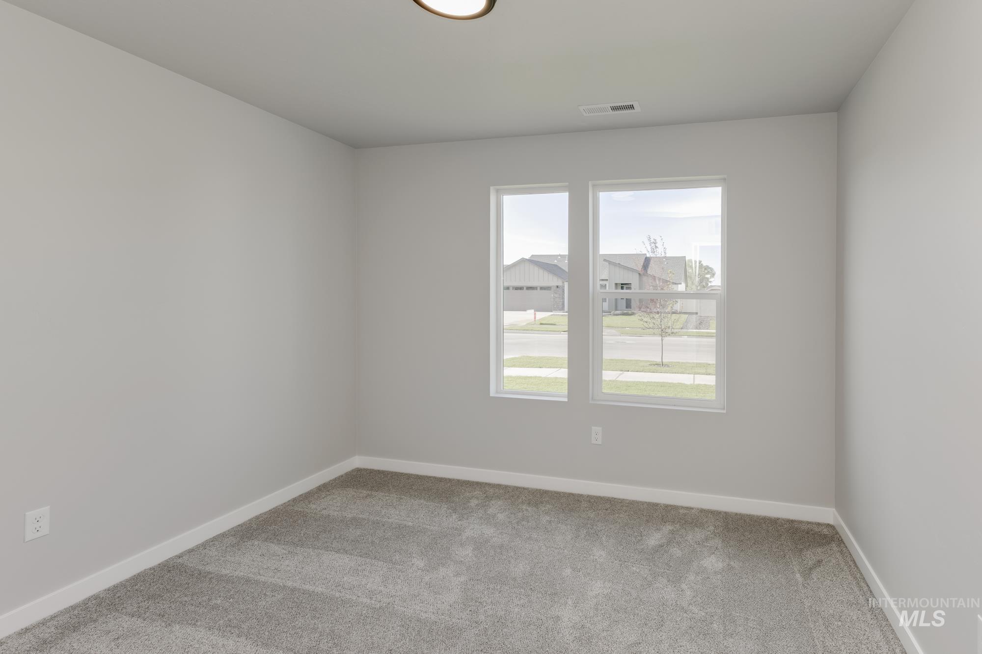 Spare room with light carpet and baseboards