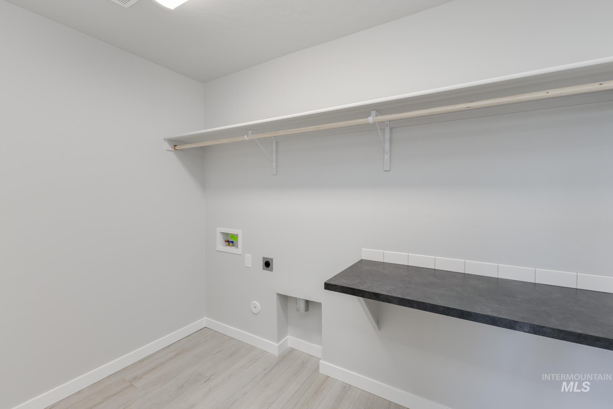 Laundry room with electric dryer hookup, light wood-type flooring, and hookup for a washing machine