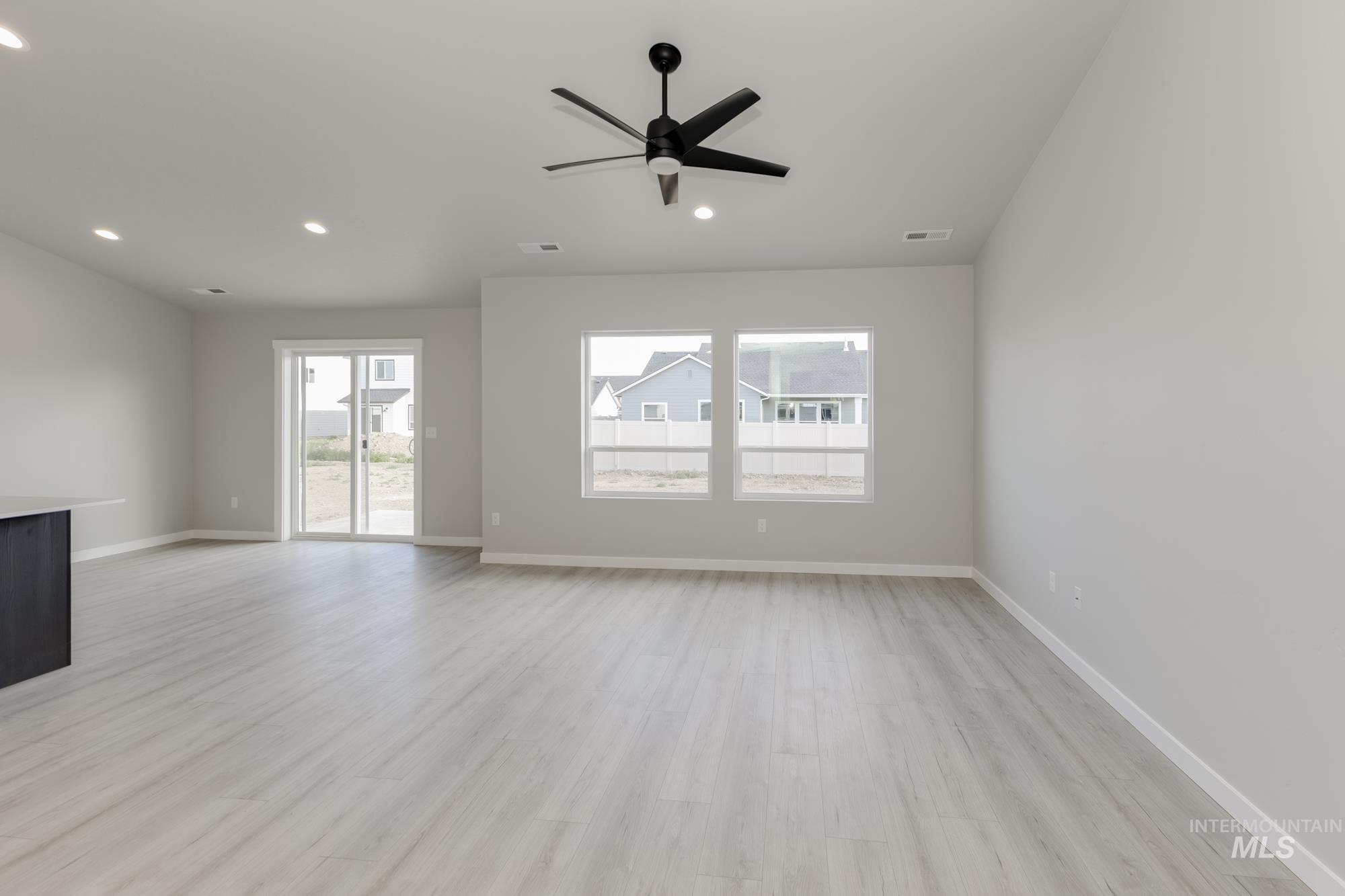 Unfurnished living room featuring light wood-style floors, ceiling fan, and recessed lighting