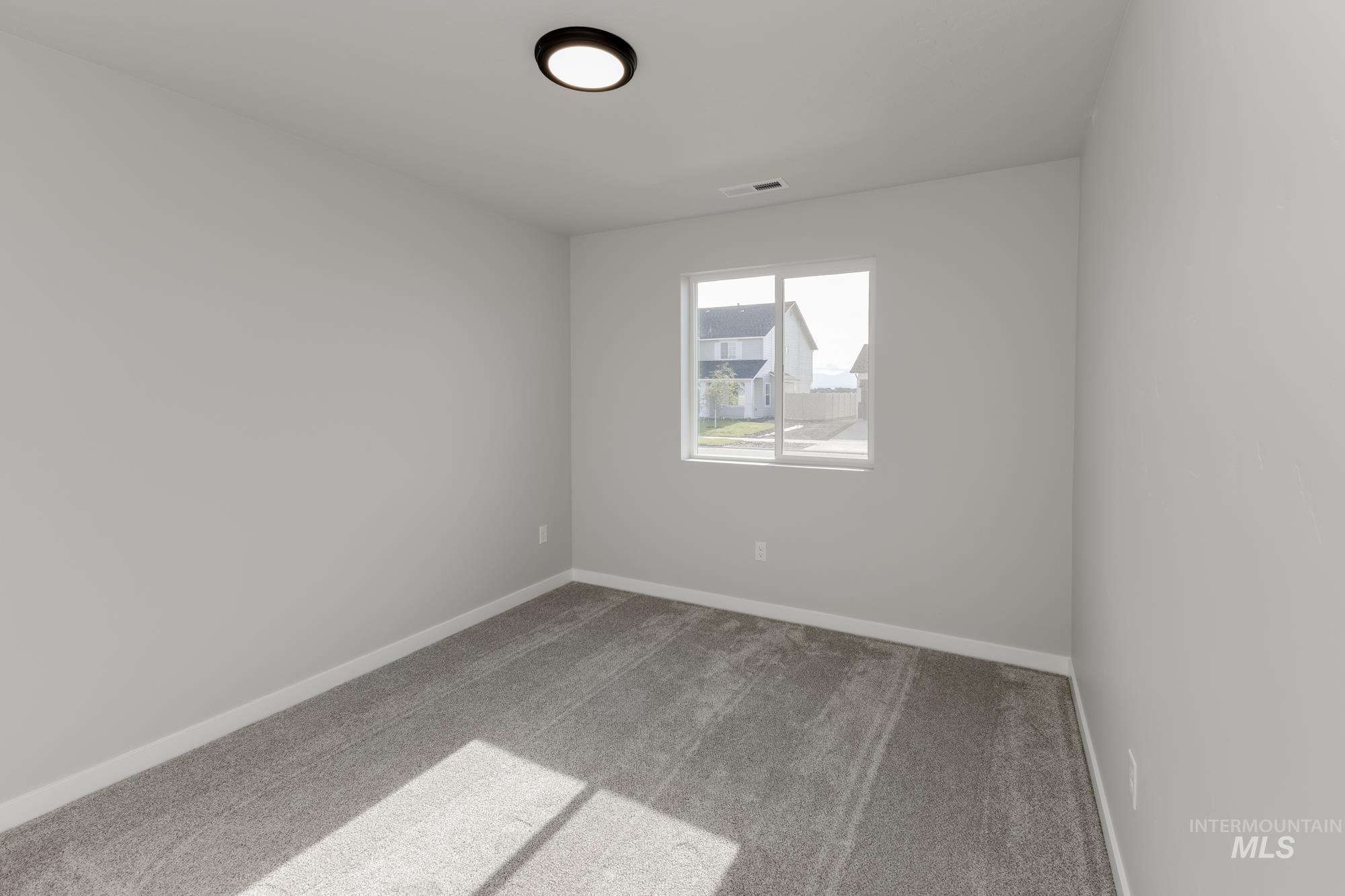 Carpeted empty room featuring baseboards