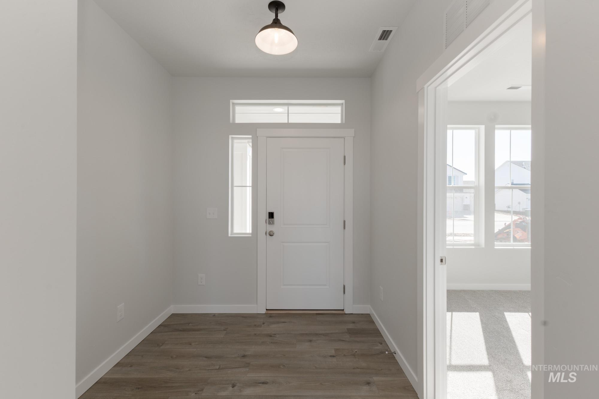 Entryway with baseboards and light wood-type flooring