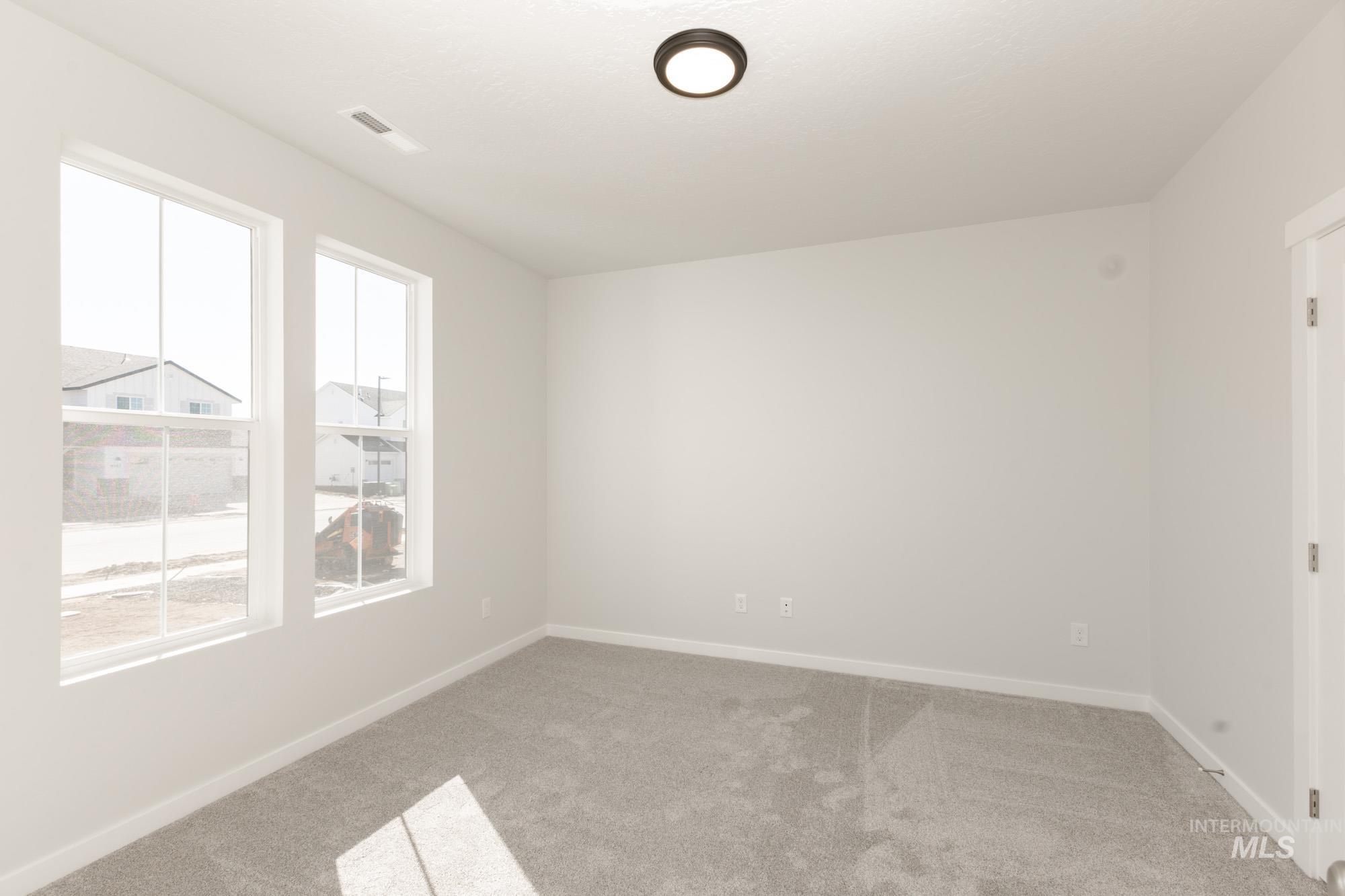 Unfurnished room with light colored carpet and baseboards
