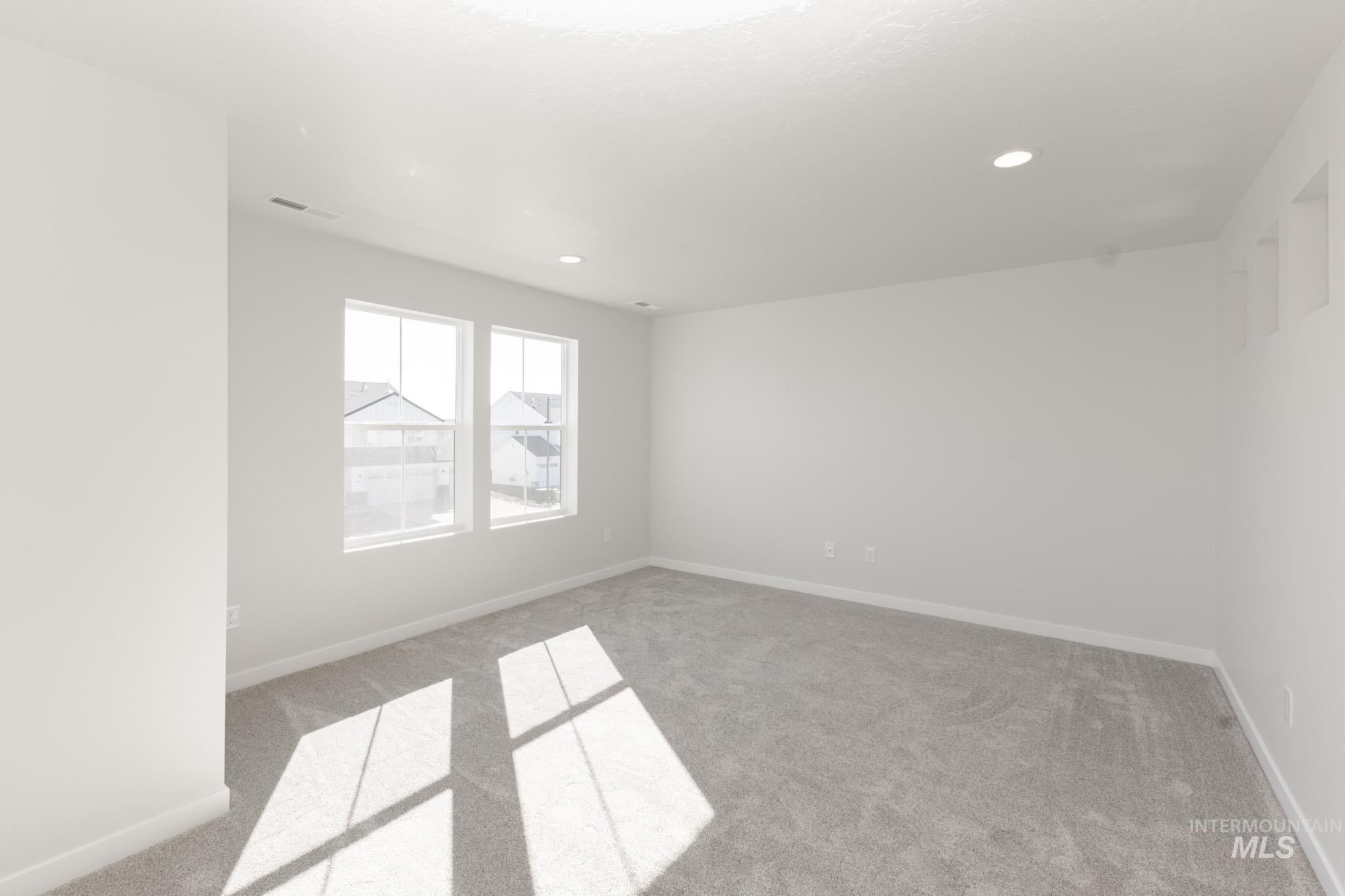 Carpeted spare room with baseboards and recessed lighting