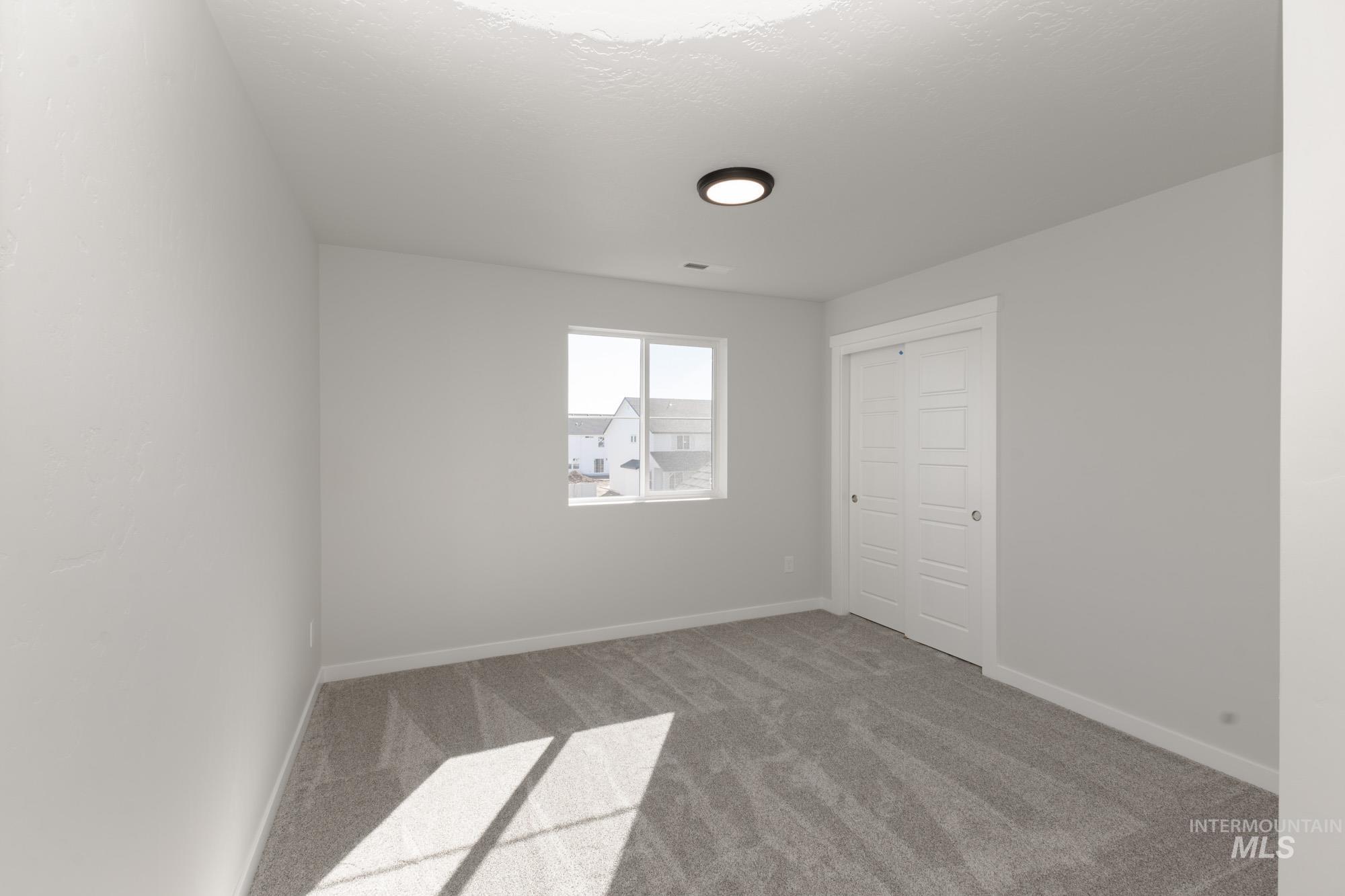 Carpeted spare room with baseboards and a textured ceiling