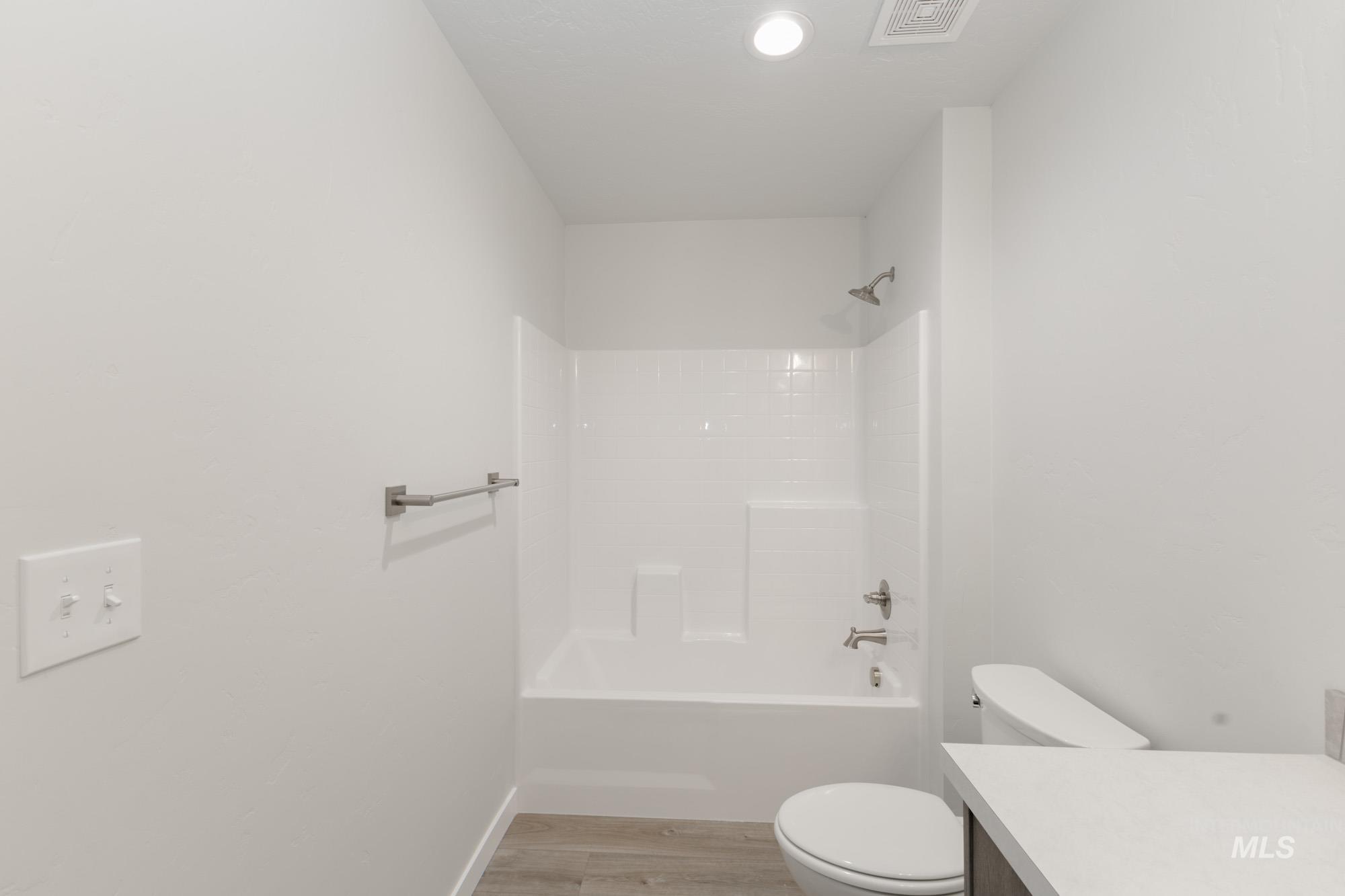 Bathroom featuring vanity, light wood-style flooring, and bathing tub / shower combination