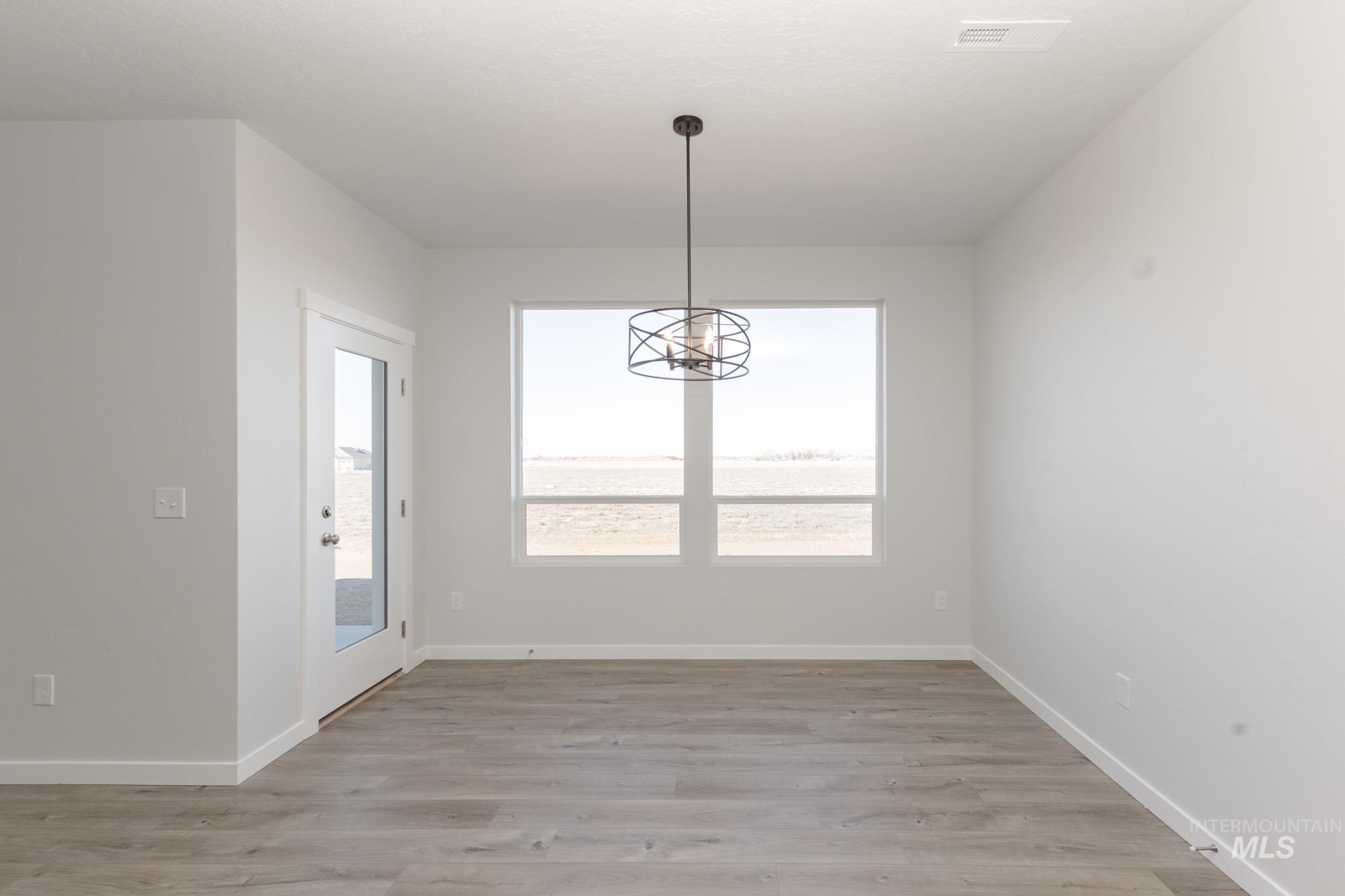 Unfurnished dining area with light wood-type flooring and a chandelier