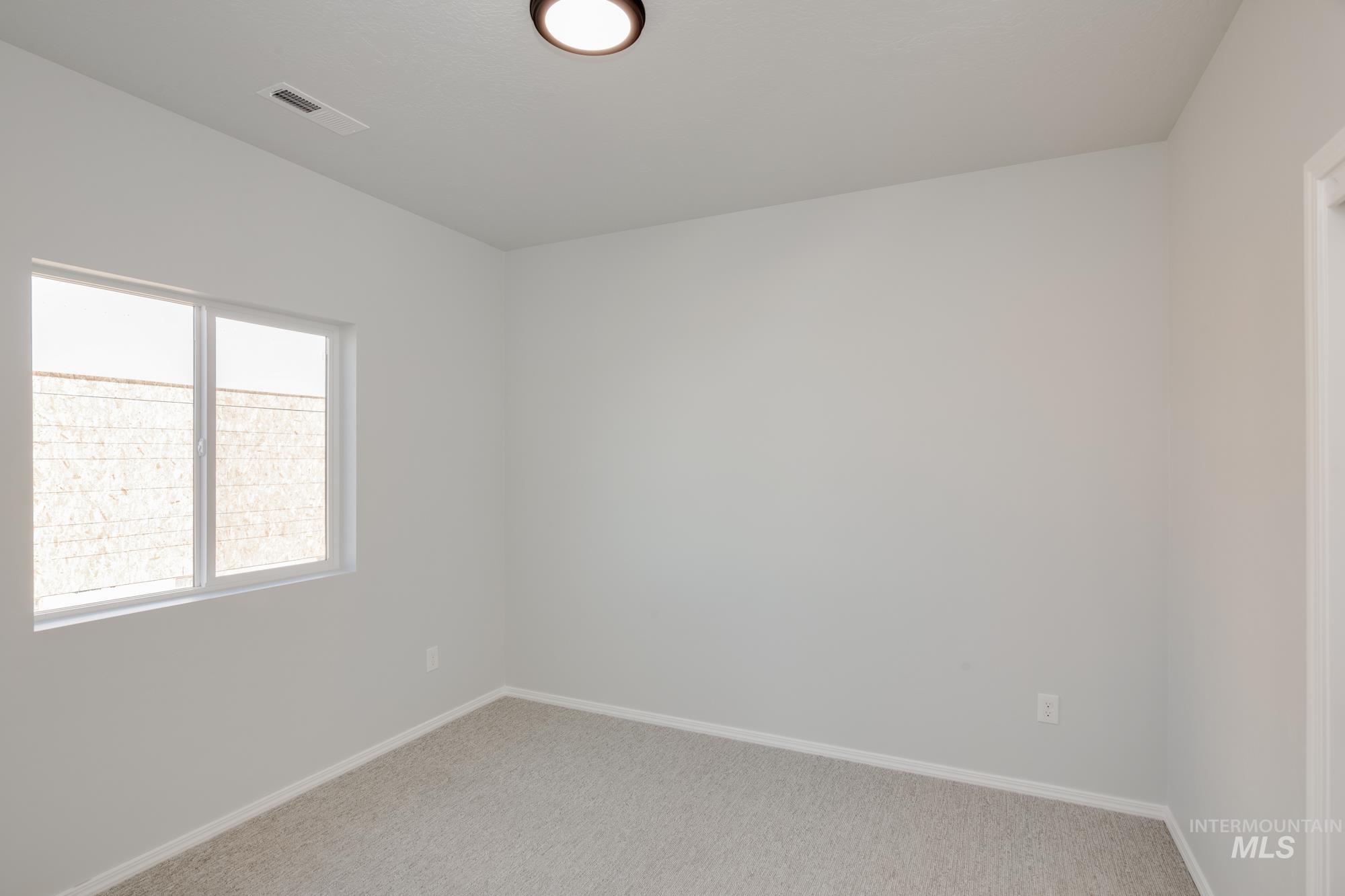 Carpeted spare room with baseboards