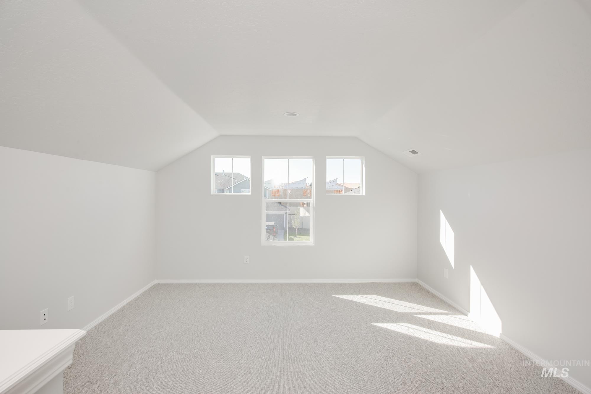 Bonus room featuring lofted ceiling and light colored carpet