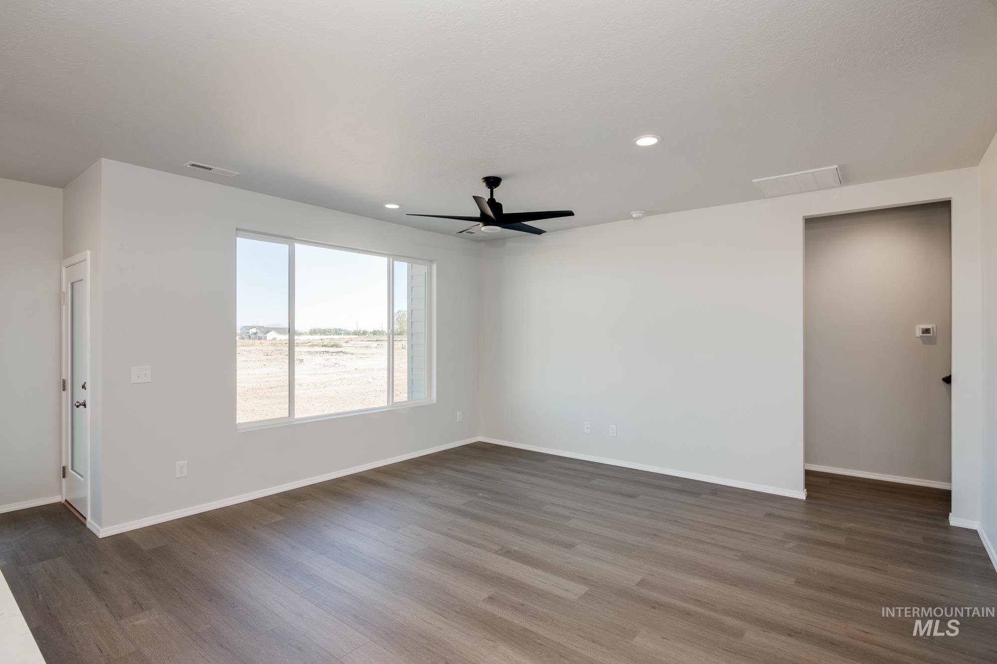 Empty room with dark wood-style floors, ceiling fan, and recessed lighting