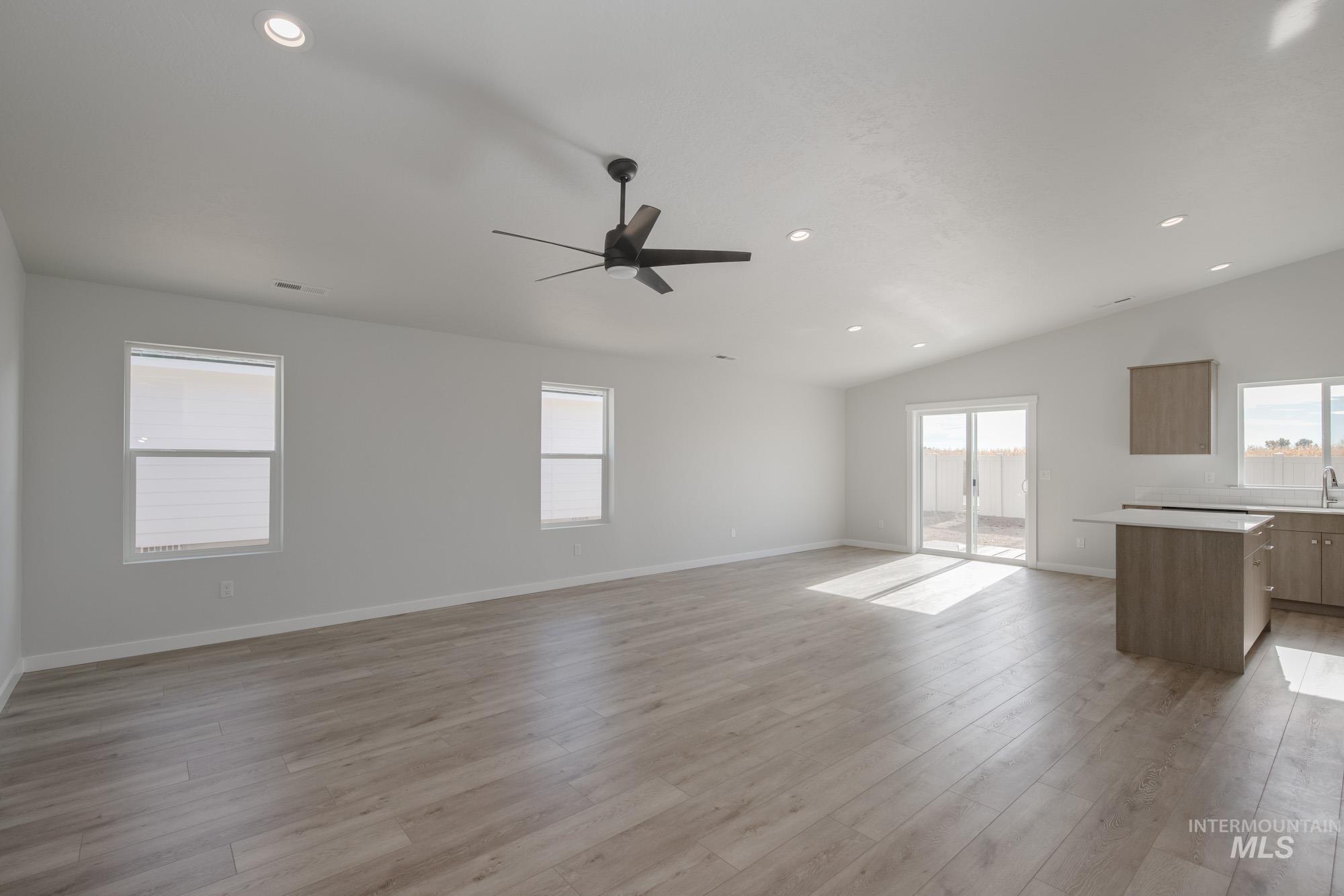 Unfurnished living room with recessed lighting, ceiling fan, light wood-style flooring, and lofted ceiling
