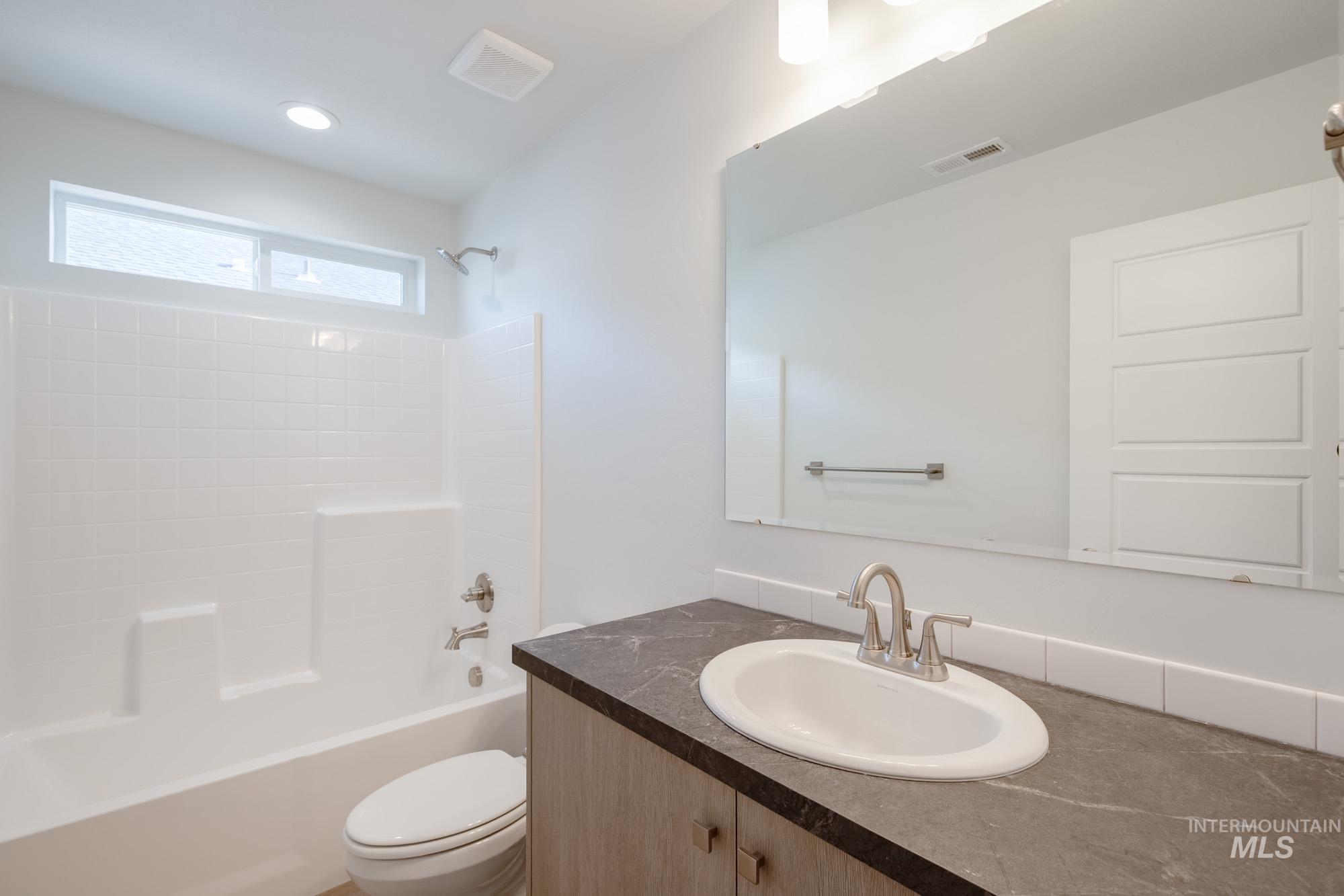 Full bathroom with bathing tub / shower combination, vanity, and recessed lighting