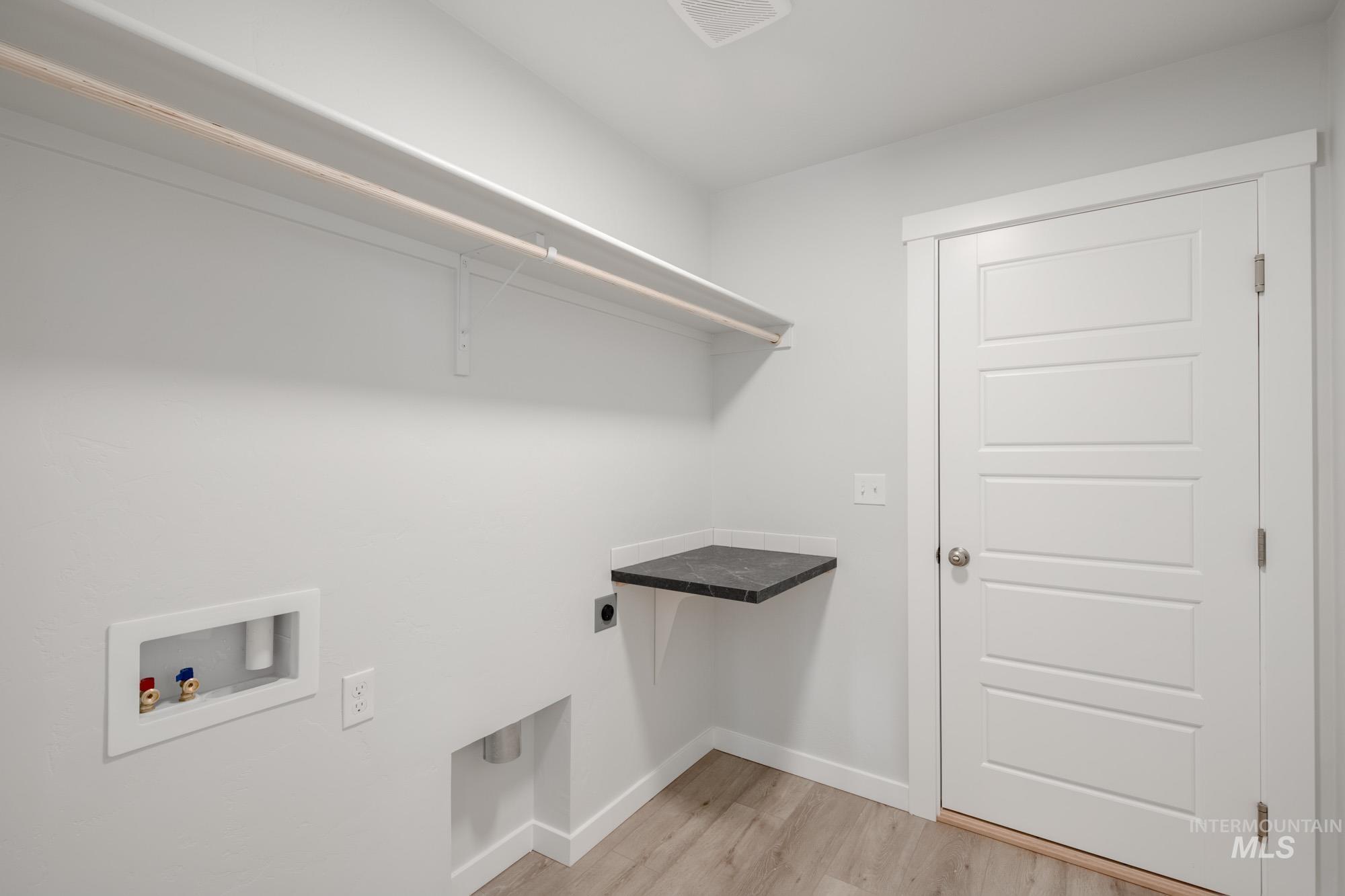 Laundry area featuring light wood finished floors, washer hookup, and hookup for an electric dryer