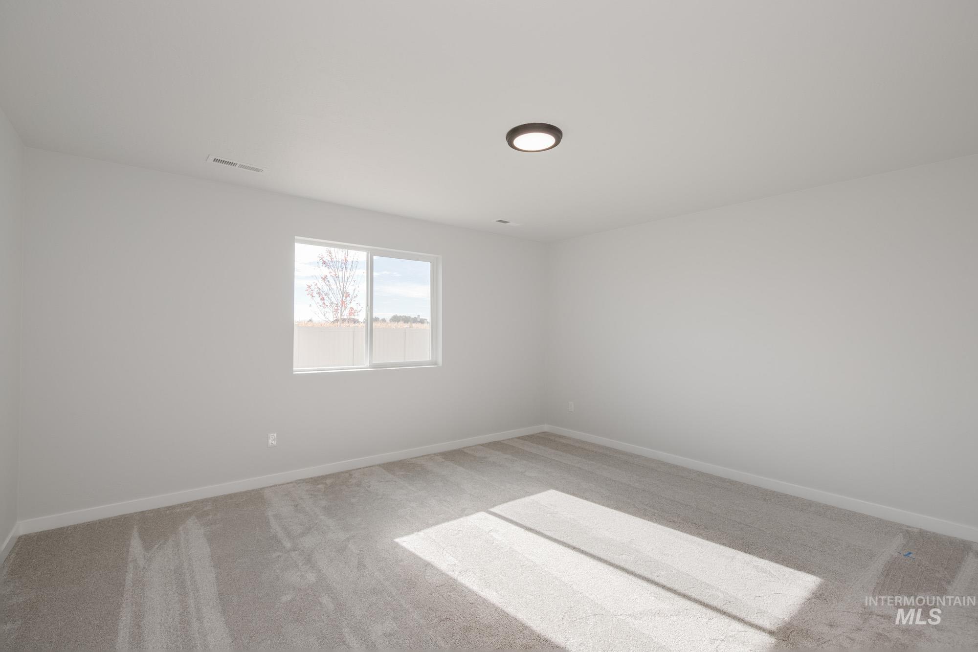 Unfurnished room with light carpet and baseboards
