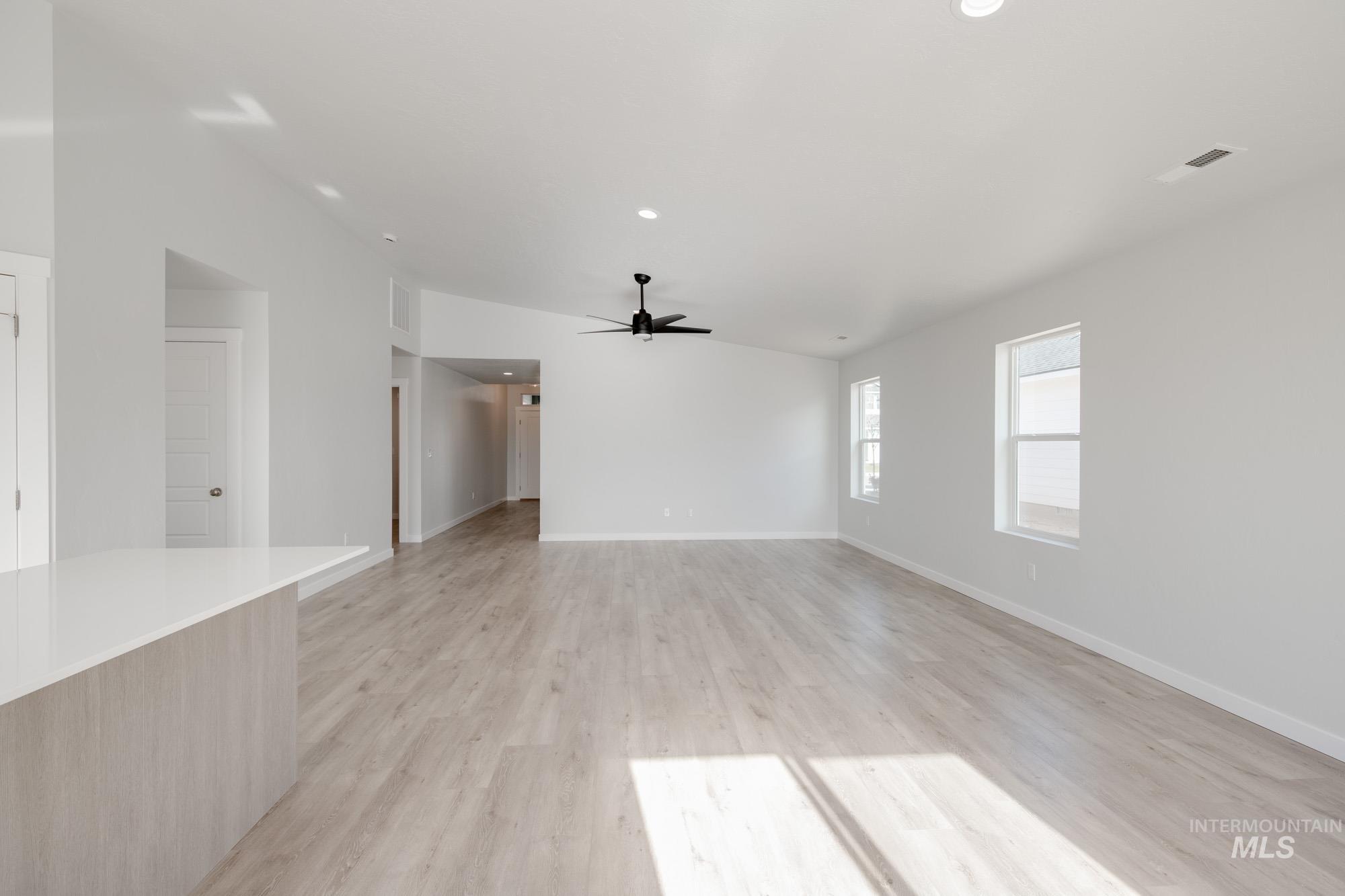 Spare room with light wood-style flooring, recessed lighting, ceiling fan, and lofted ceiling