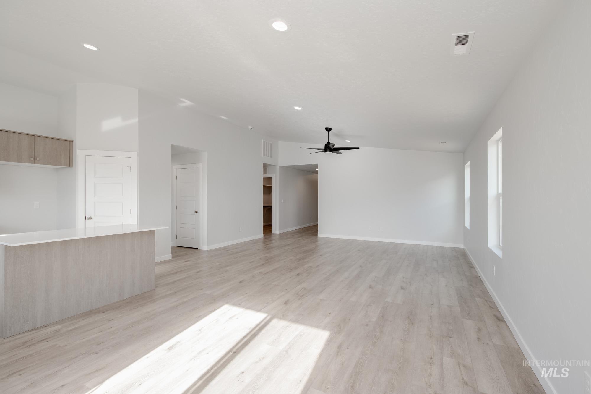 Unfurnished living room featuring light wood-type flooring, ceiling fan, and recessed lighting
