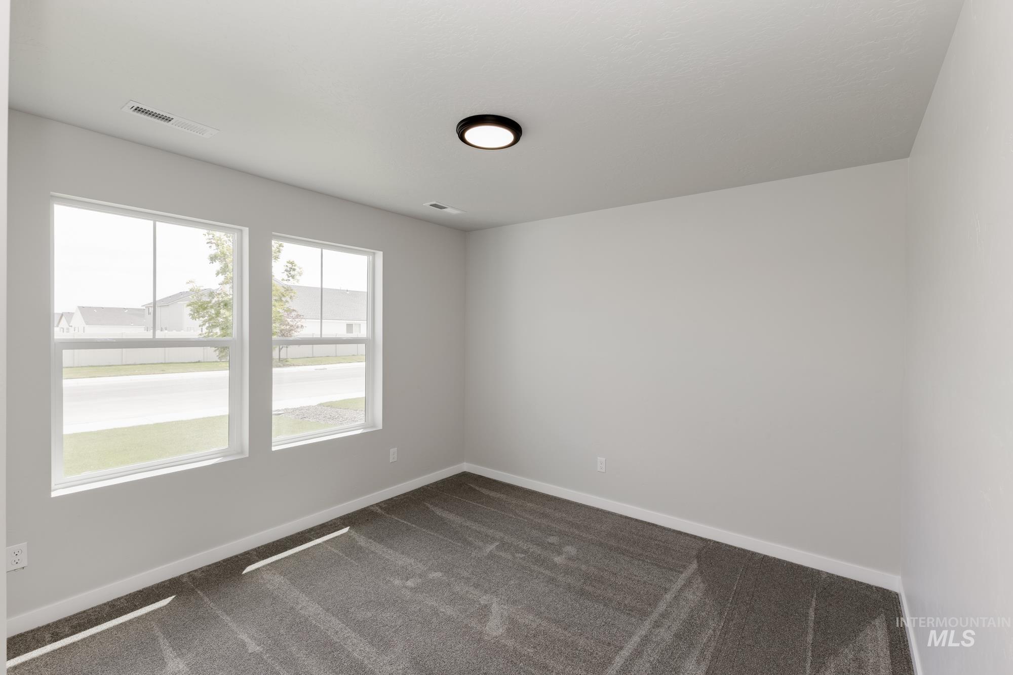 Empty room with dark carpet and baseboards