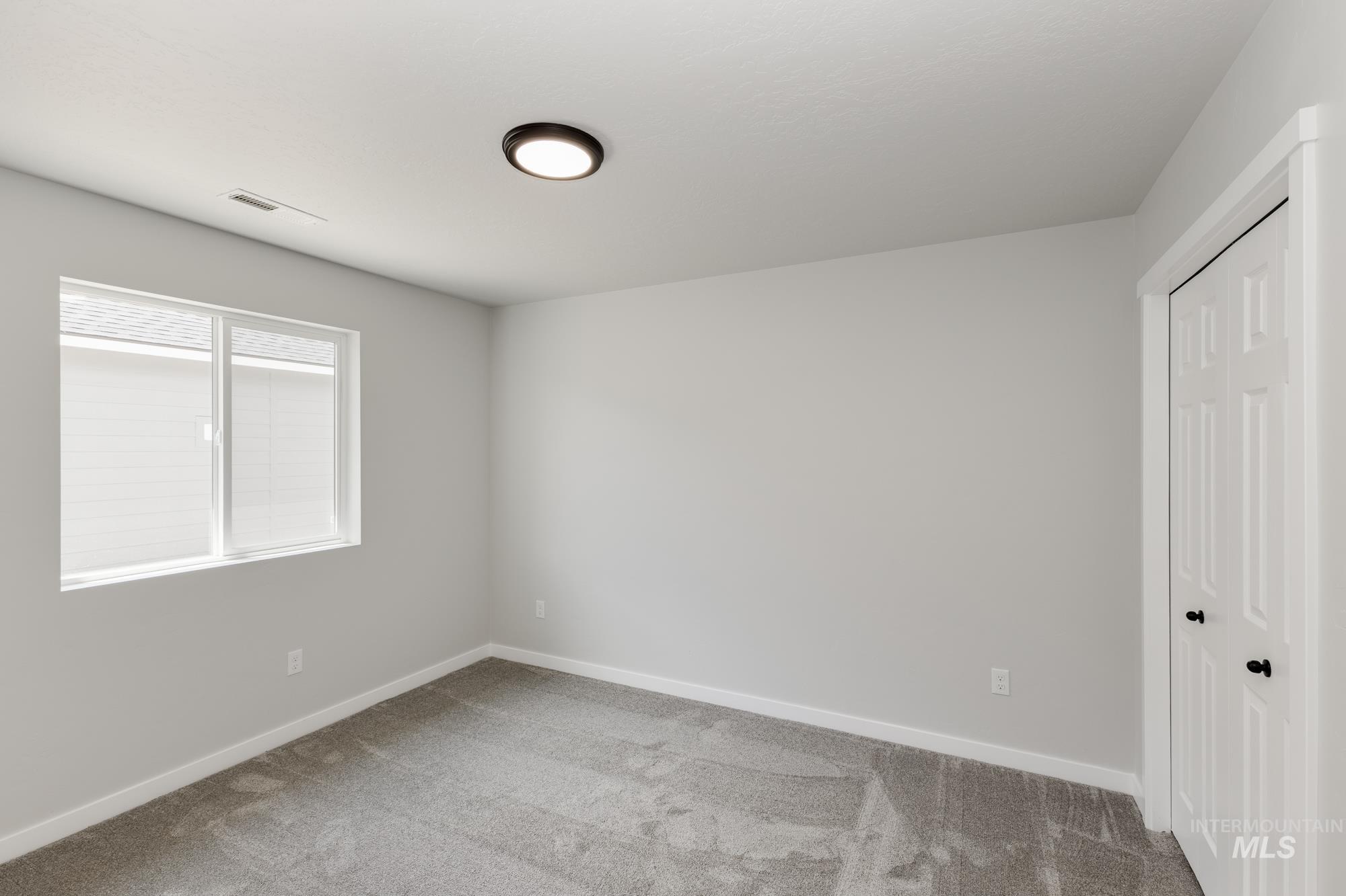 Empty room featuring light carpet and baseboards