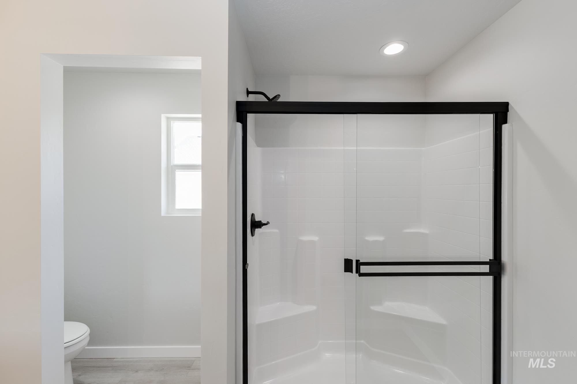 Bathroom featuring a stall shower and light wood-style flooring