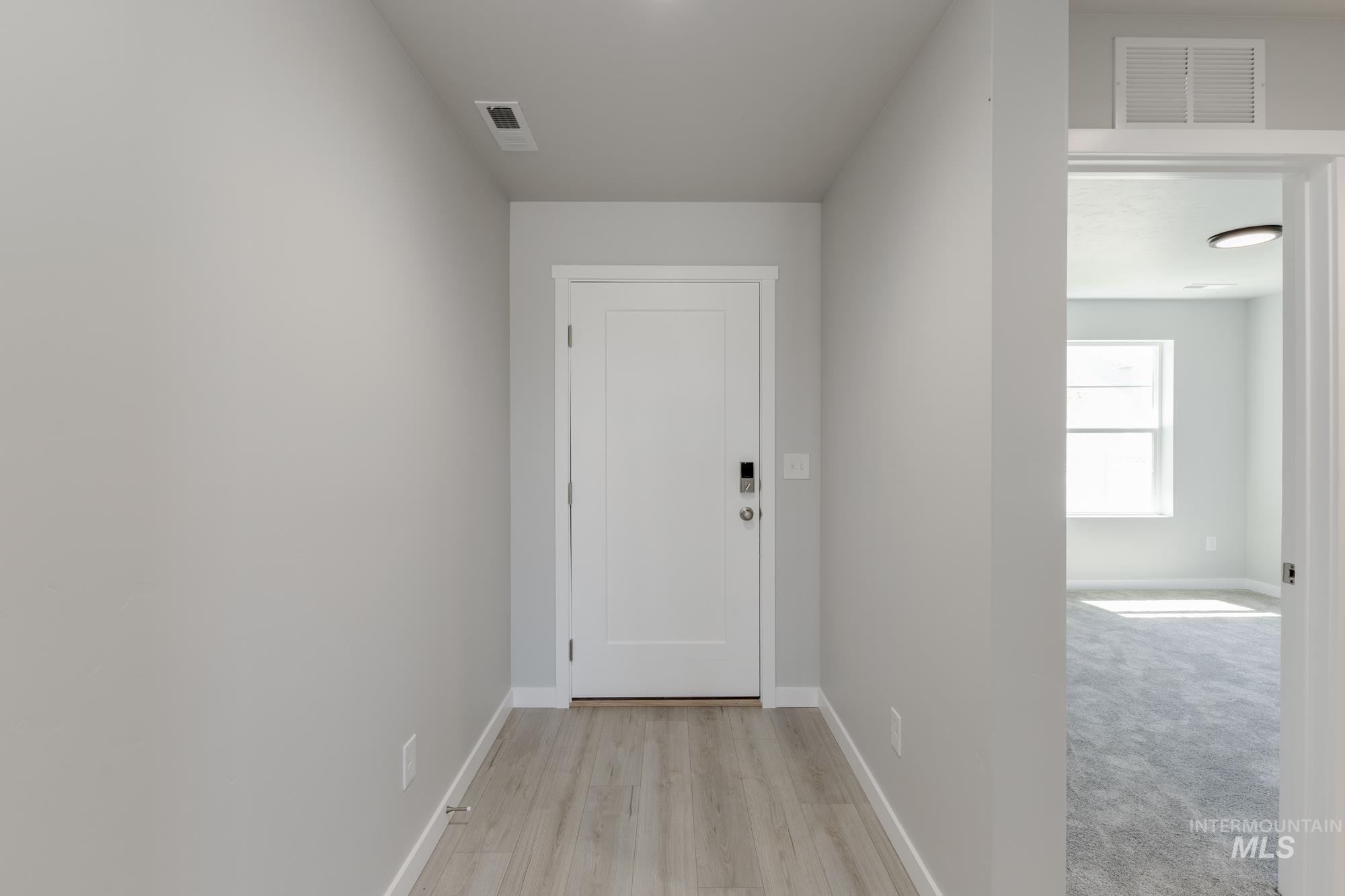 Corridor with baseboards and light wood-style floors
