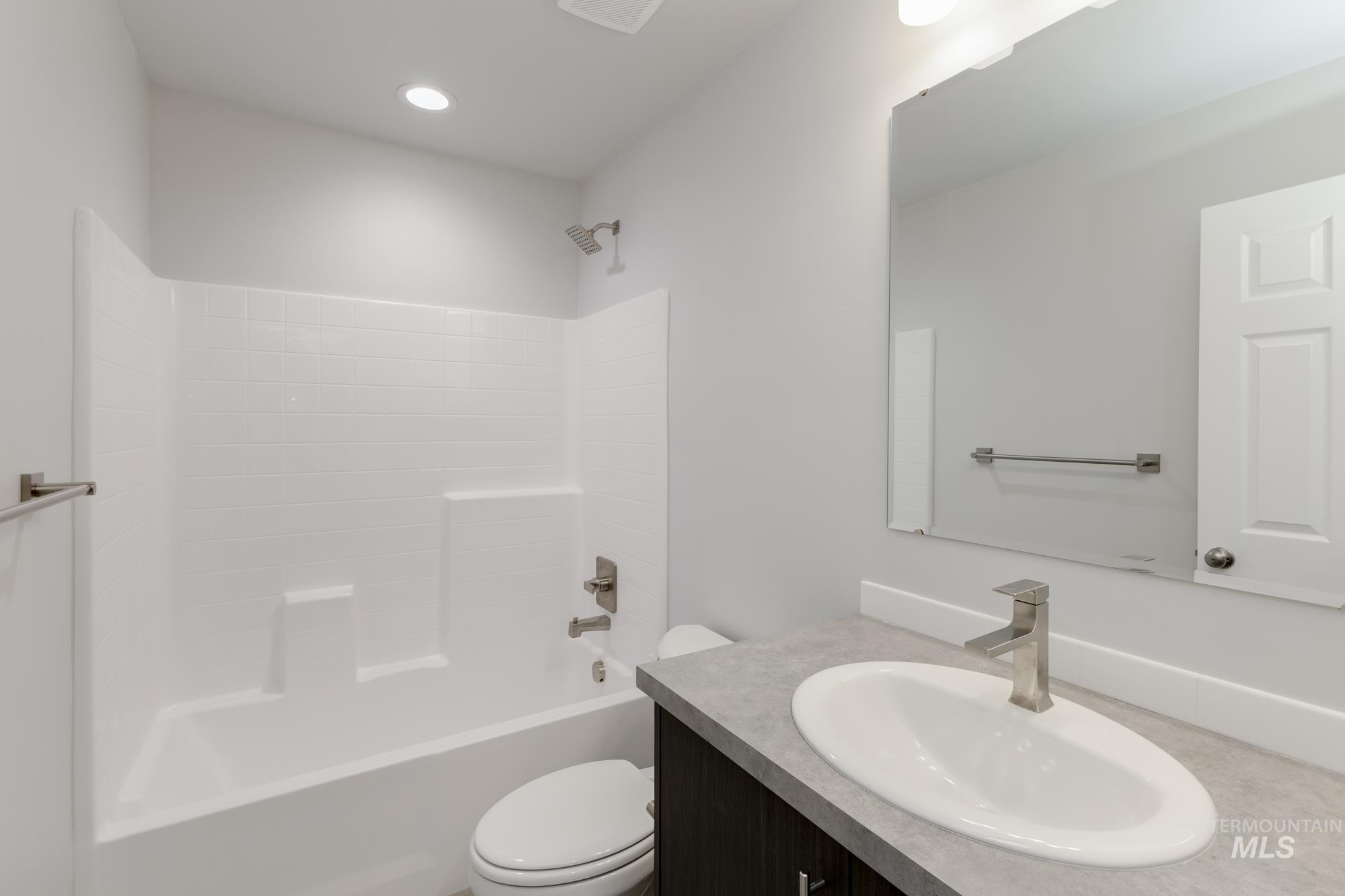 Bathroom featuring shower / washtub combination, vanity, and recessed lighting