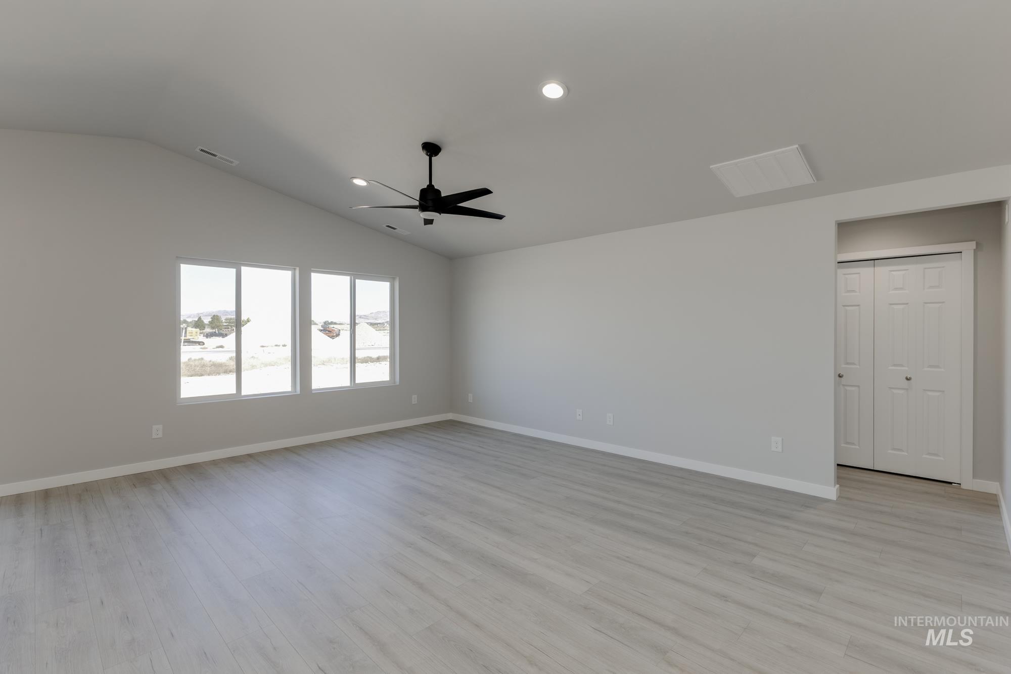 Spare room with light wood finished floors, recessed lighting, lofted ceiling, and ceiling fan