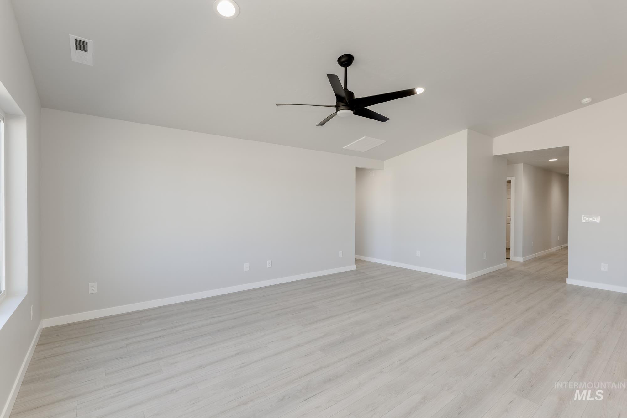 Unfurnished room featuring light wood-style flooring, recessed lighting, a ceiling fan, and vaulted ceiling