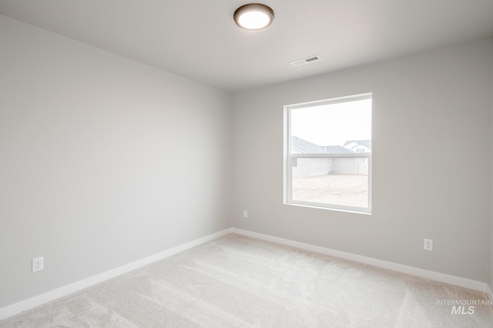 Carpeted empty room featuring baseboards