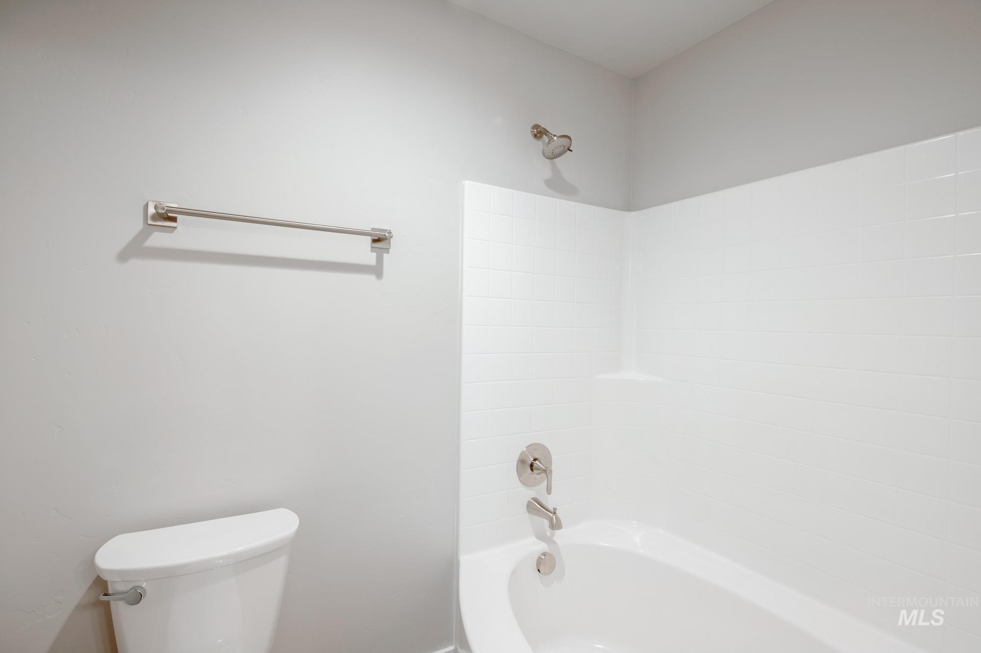 Full bath featuring washtub / shower combination and toilet