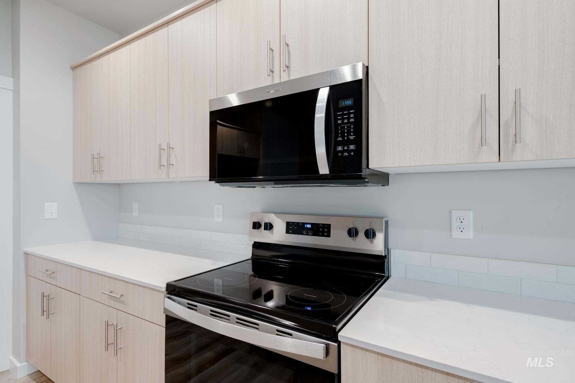 Kitchen with light brown cabinetry, stainless steel appliances, and modern cabinets