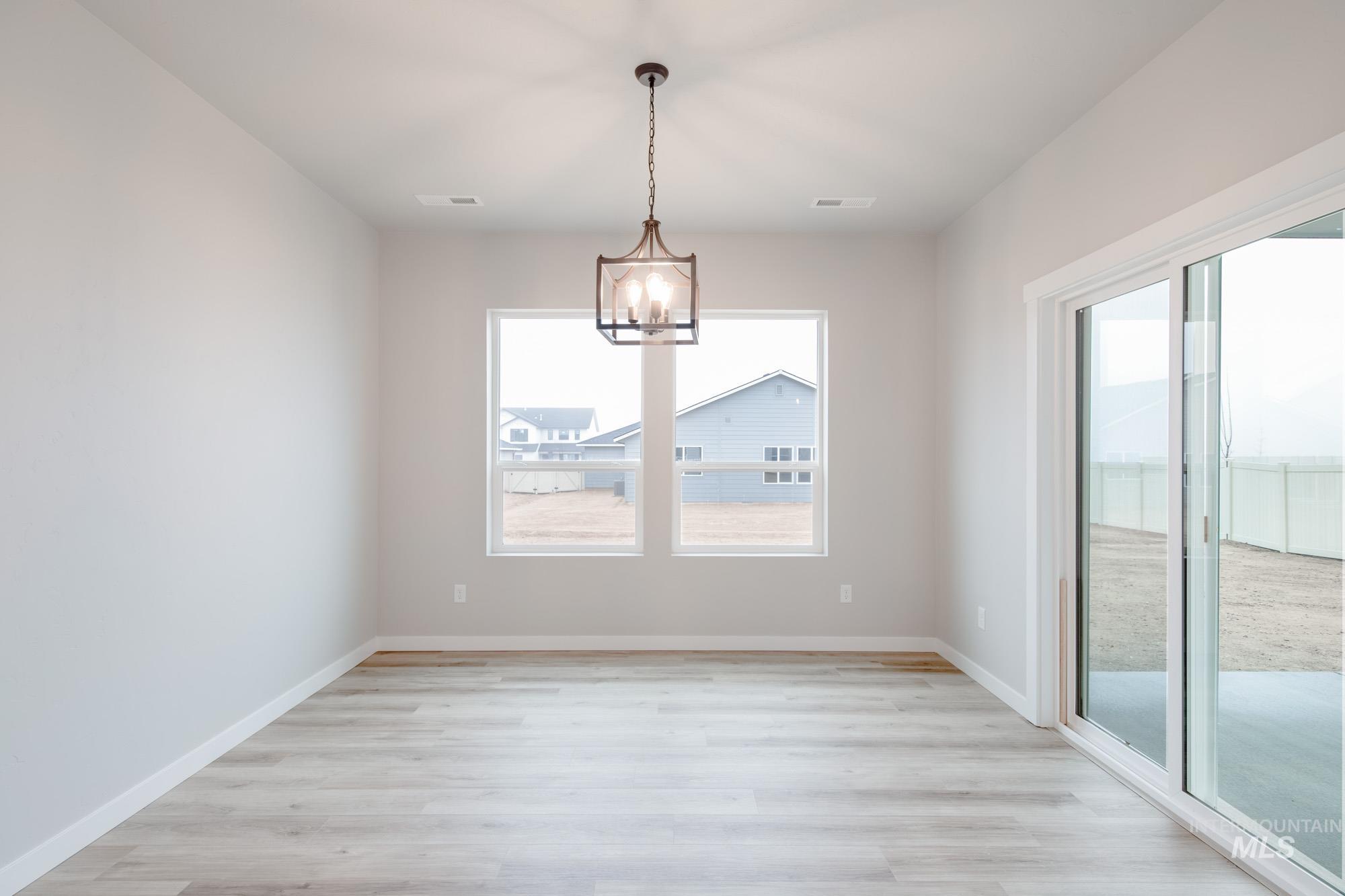 Unfurnished dining area with light wood finished floors and a chandelier