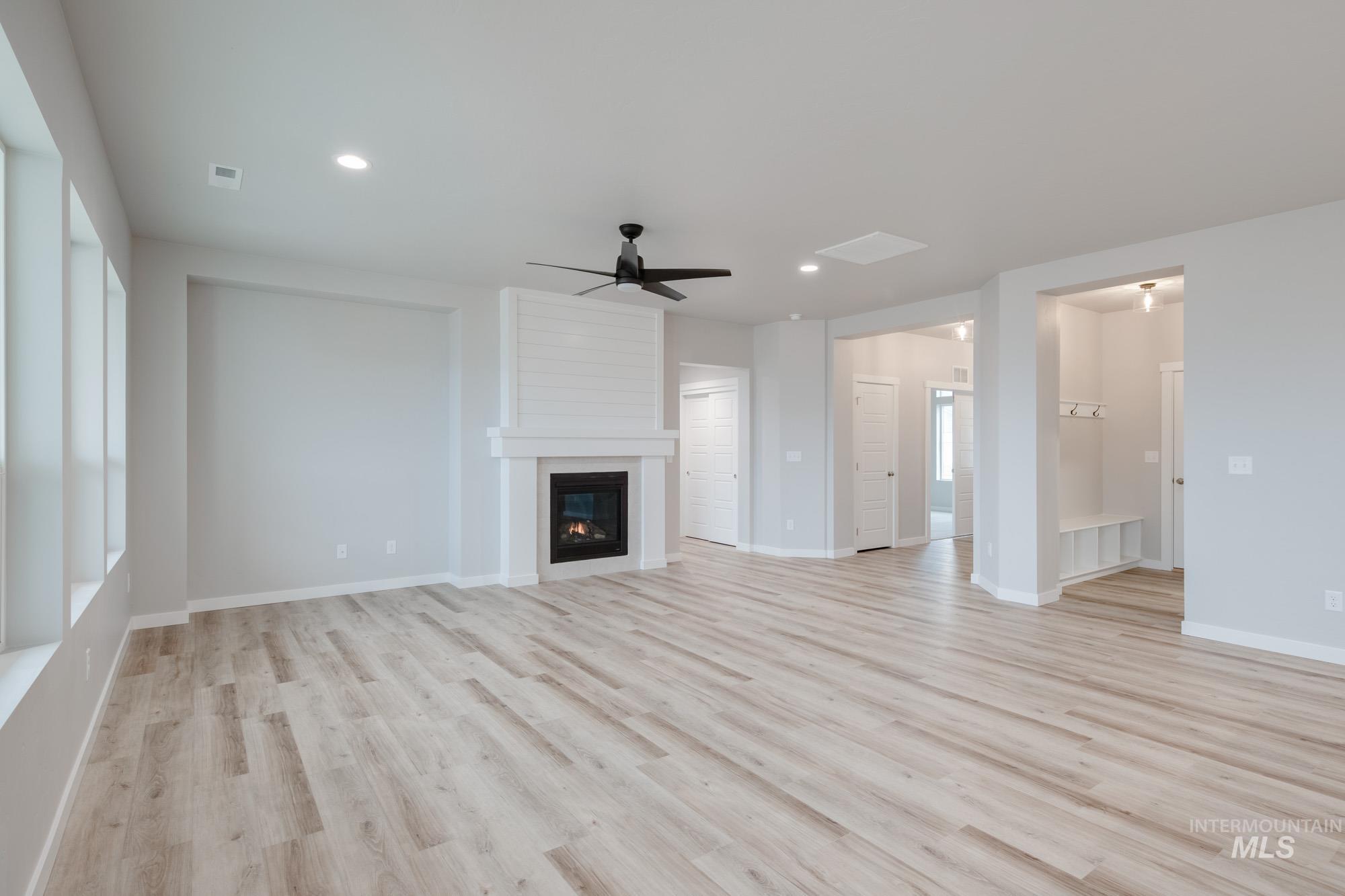 Unfurnished living room with ceiling fan, light wood-type flooring, a fireplace, and recessed lighting