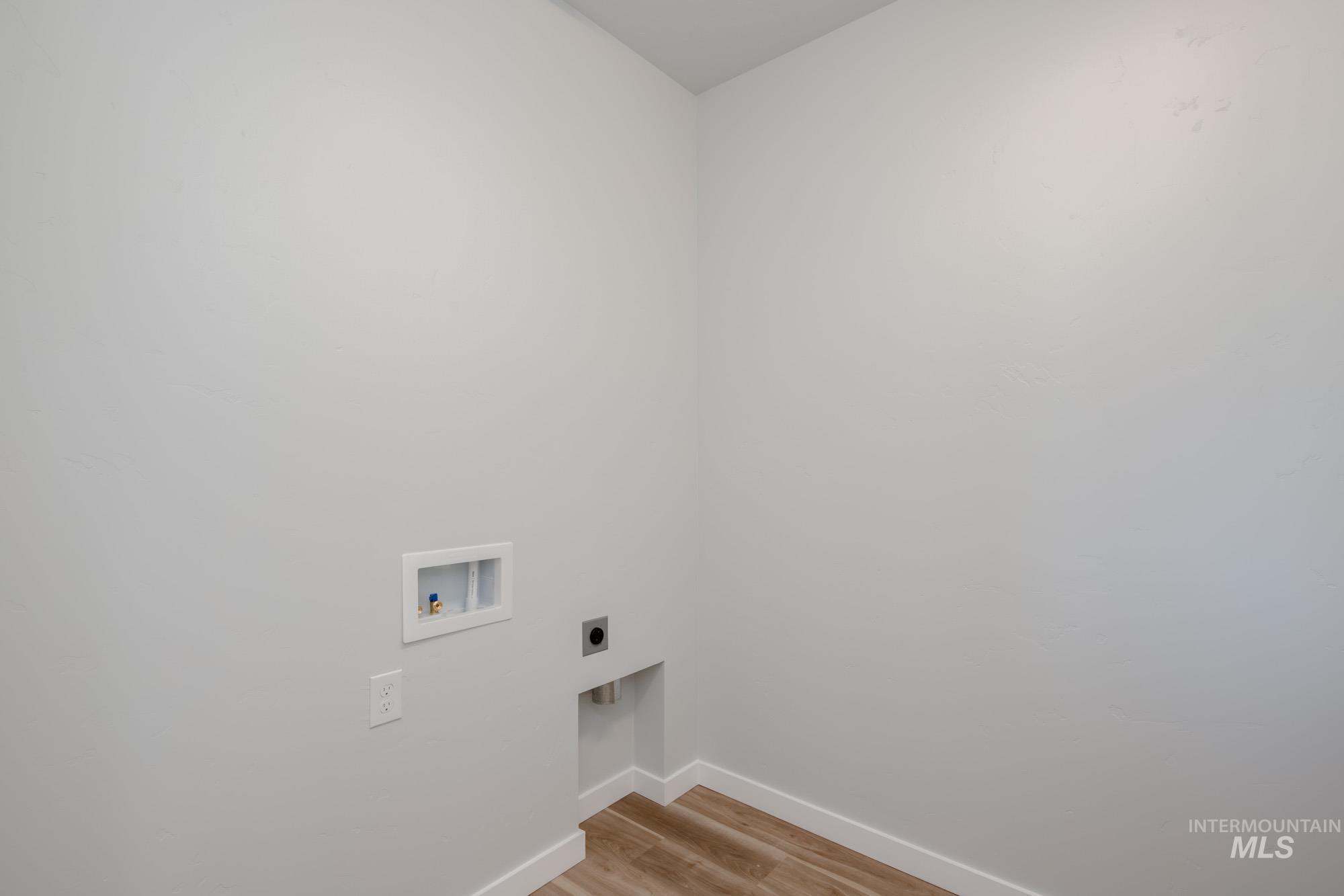 Washroom featuring light wood finished floors, washer hookup, and electric dryer hookup