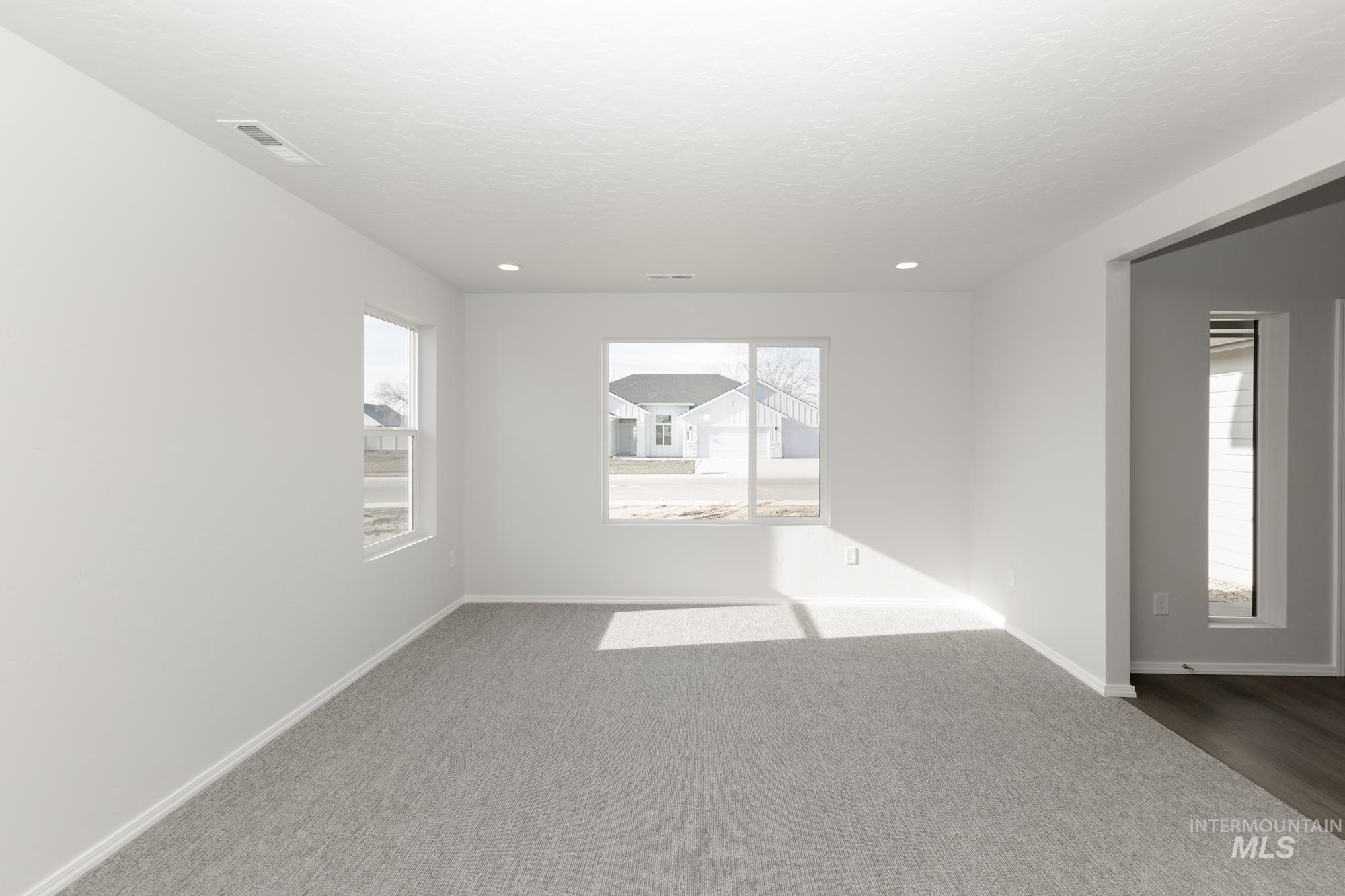 Carpeted empty room featuring baseboards and a textured ceiling