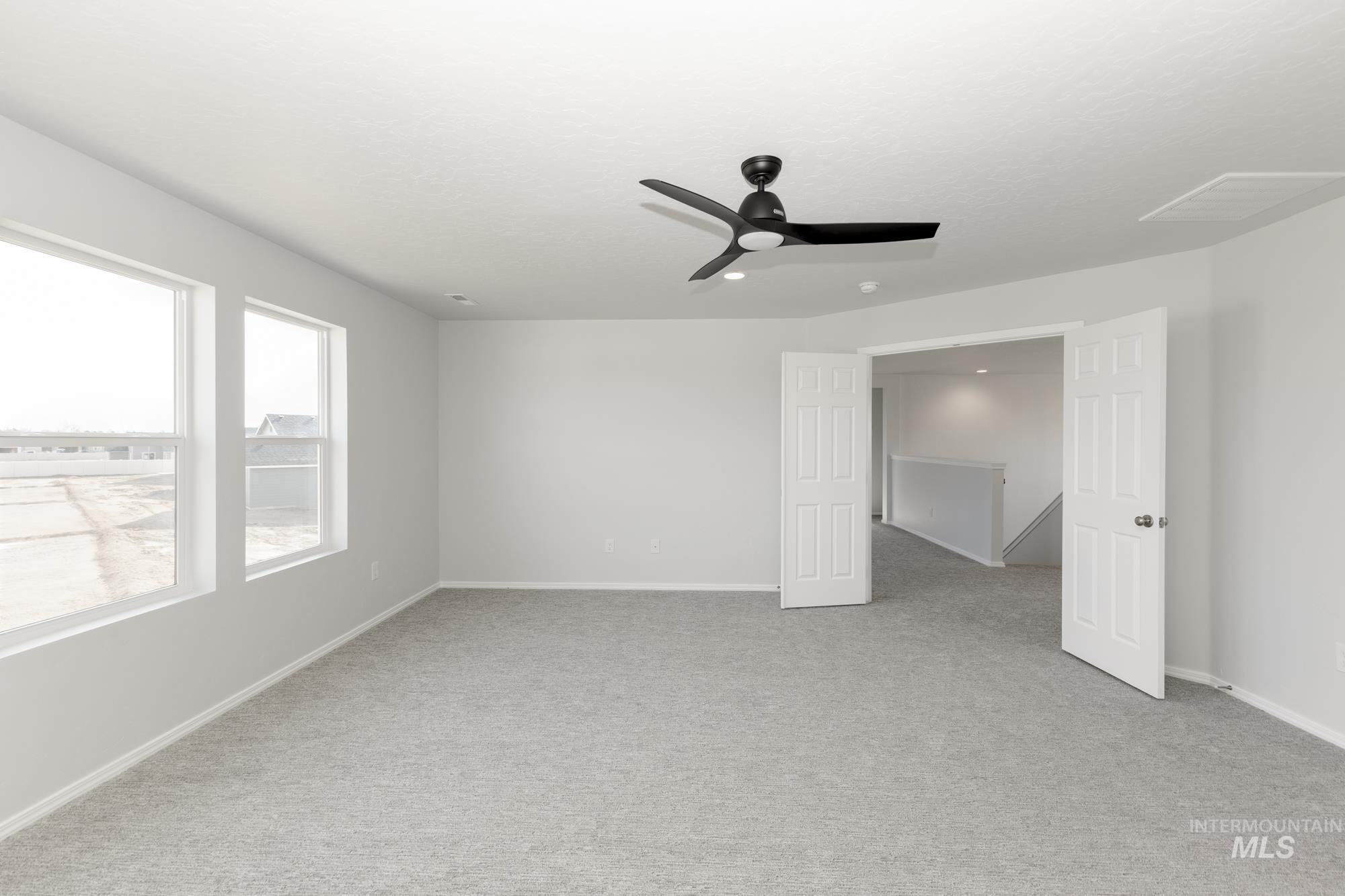 Unfurnished bedroom featuring light colored carpet and ceiling fan