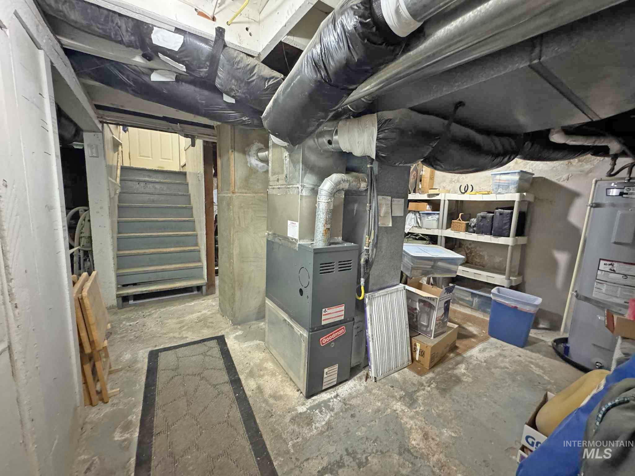 Utility room featuring water heater and heating unit