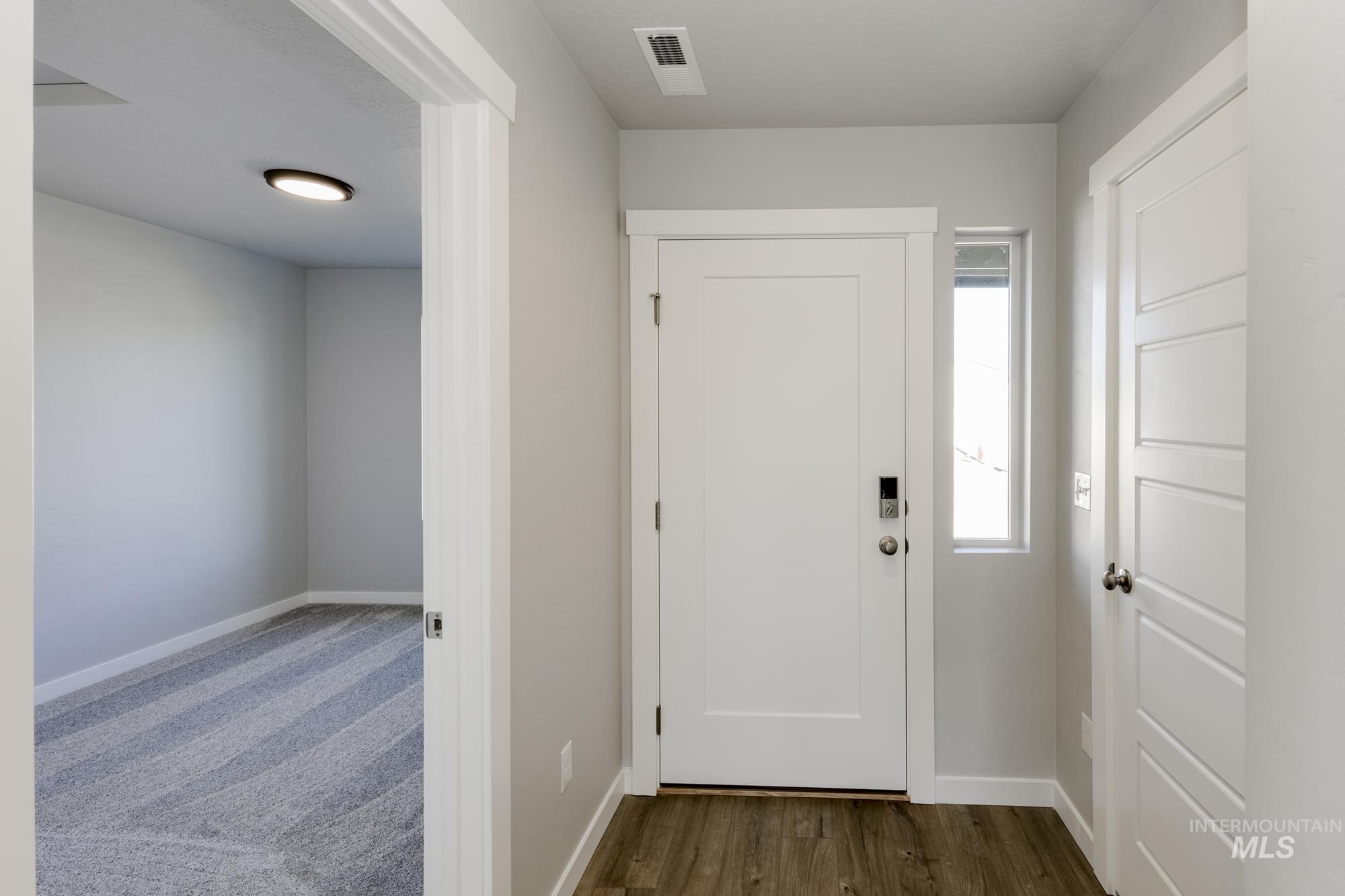 Entrance foyer featuring baseboards and dark wood-style flooring