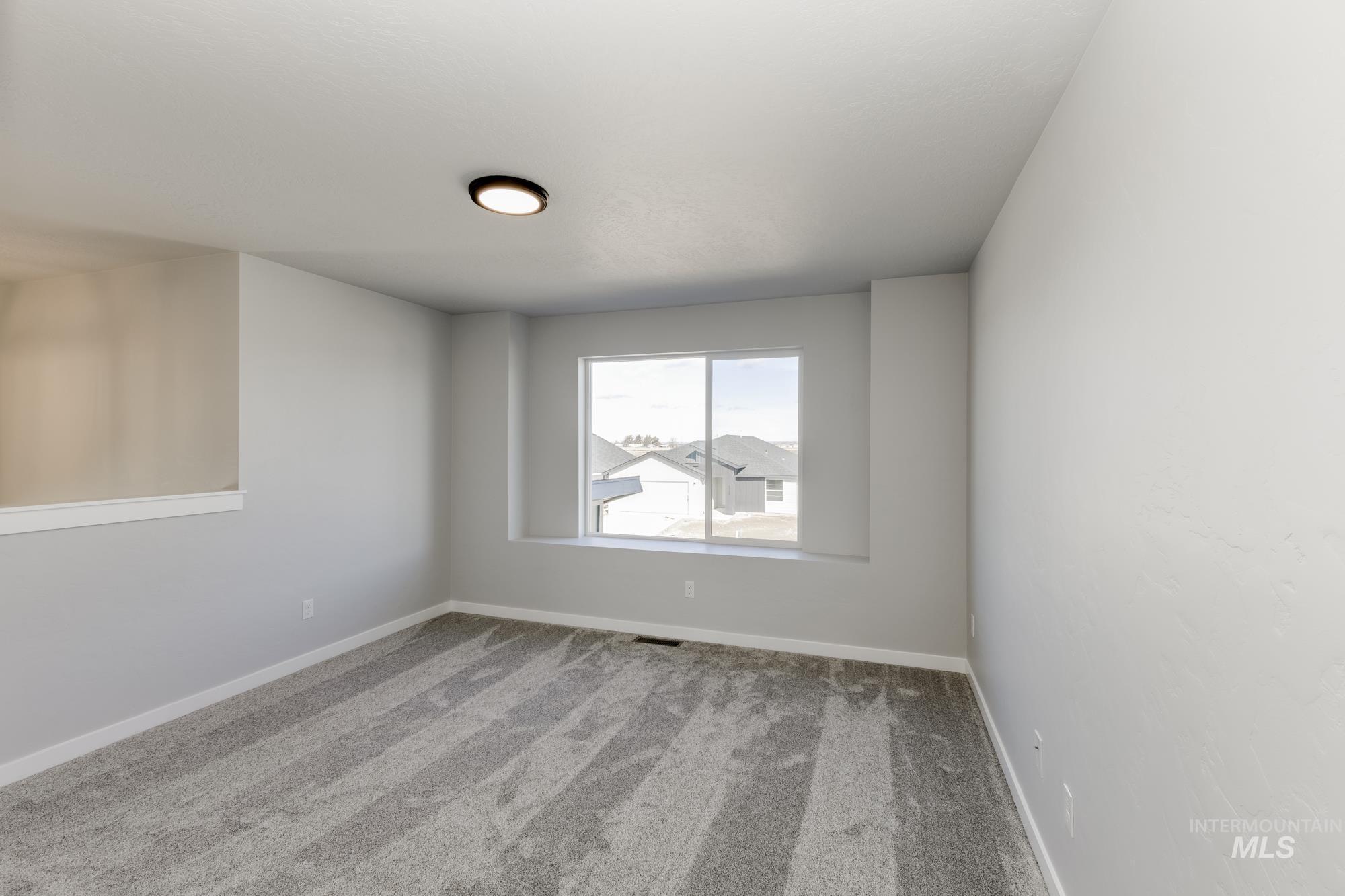 Carpeted empty room with baseboards