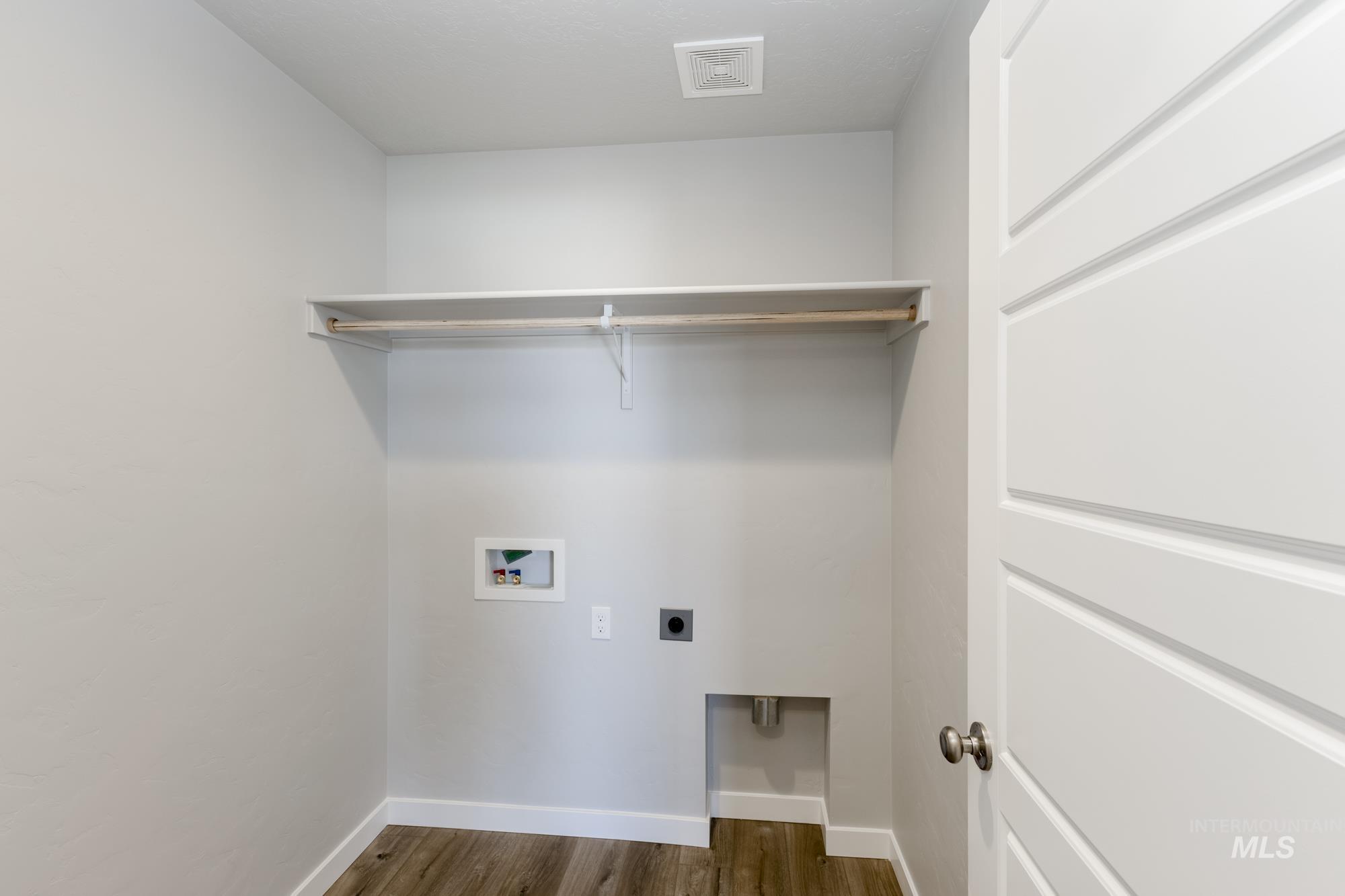 Washroom with dark wood-style flooring, washer hookup, and hookup for an electric dryer