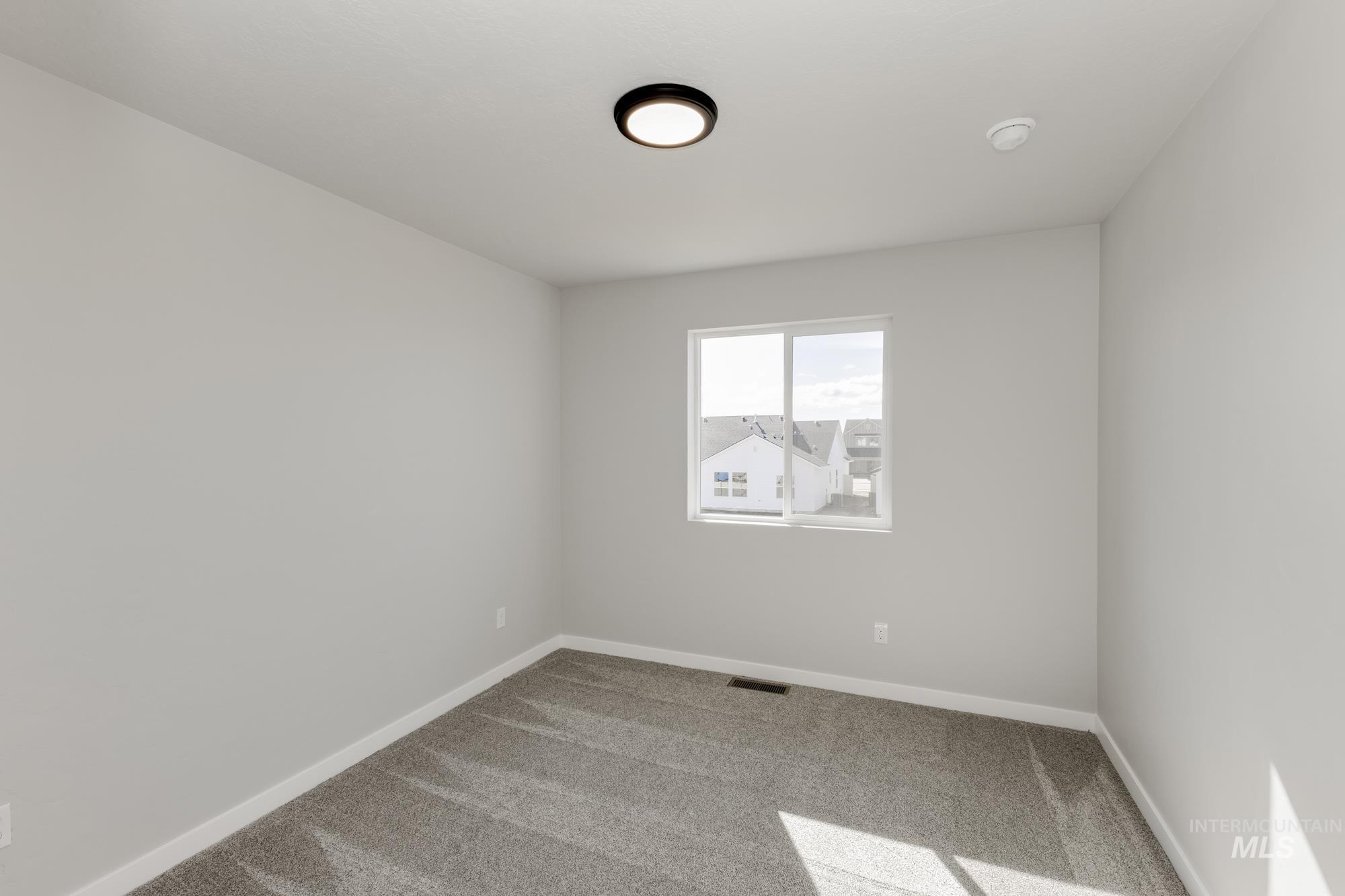 Carpeted spare room with baseboards