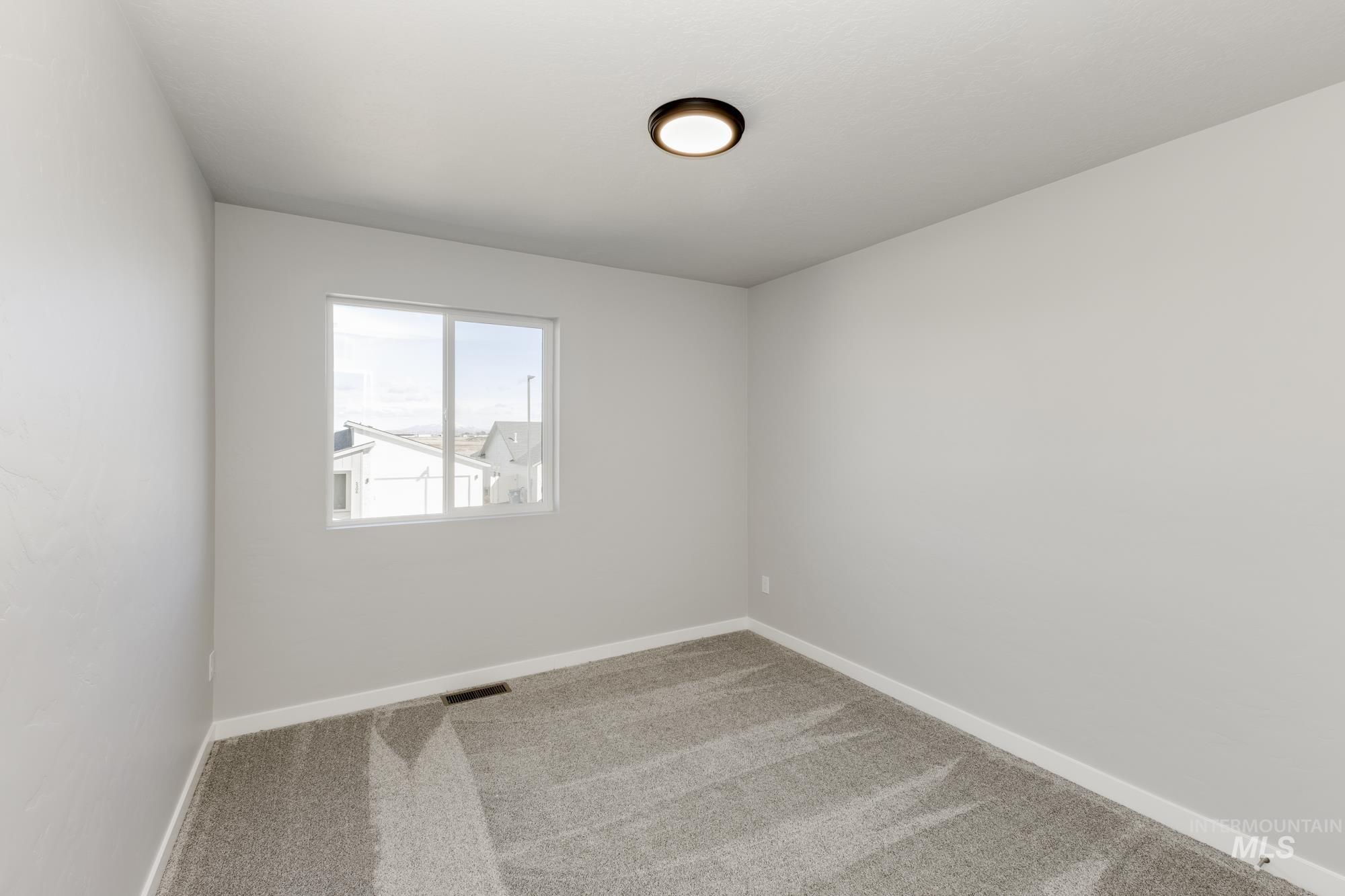 Carpeted spare room with baseboards